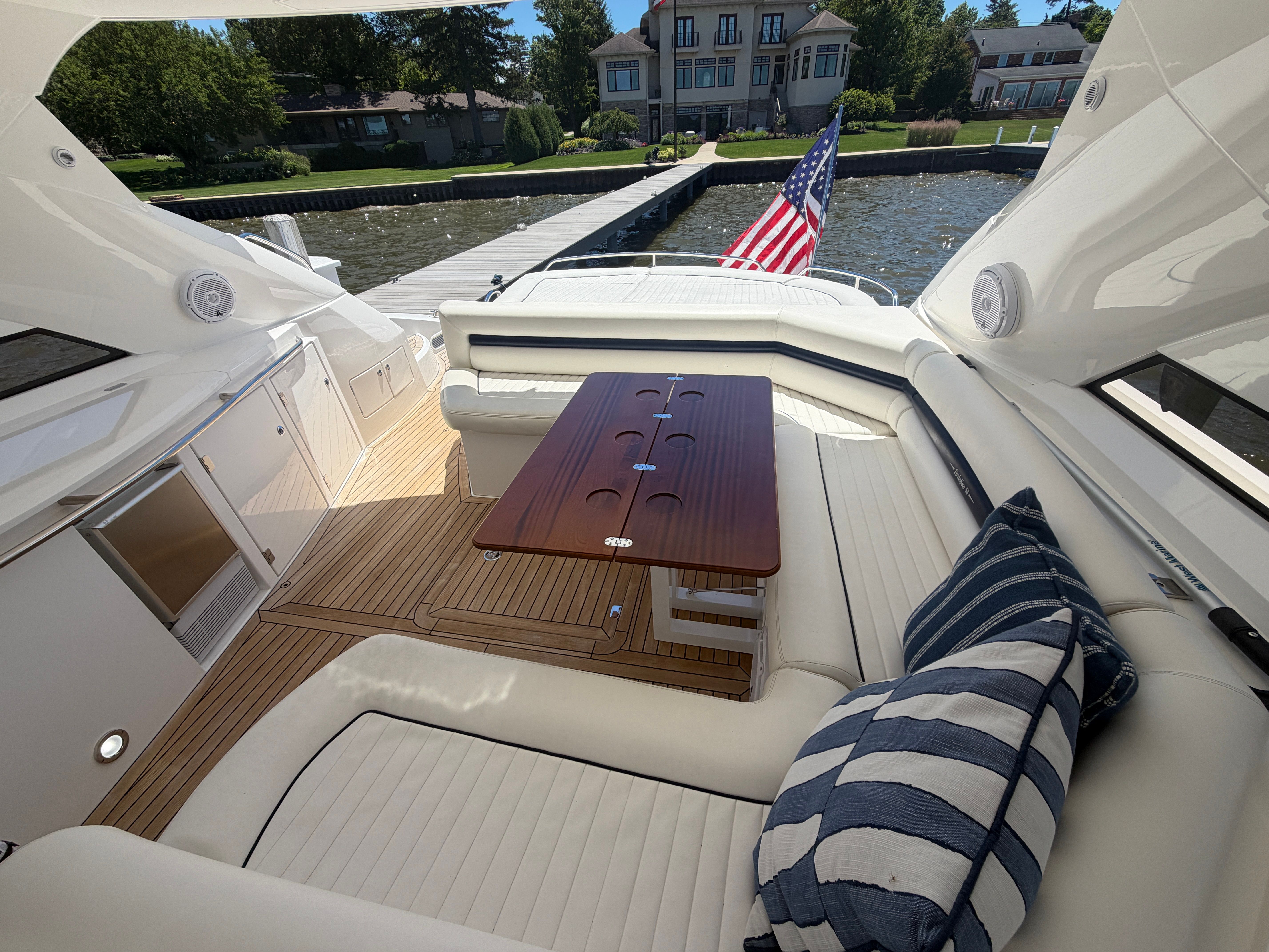 The image shows the cockpit of a Sunseeker Portofino 53 with elegant seating and a wooden table.