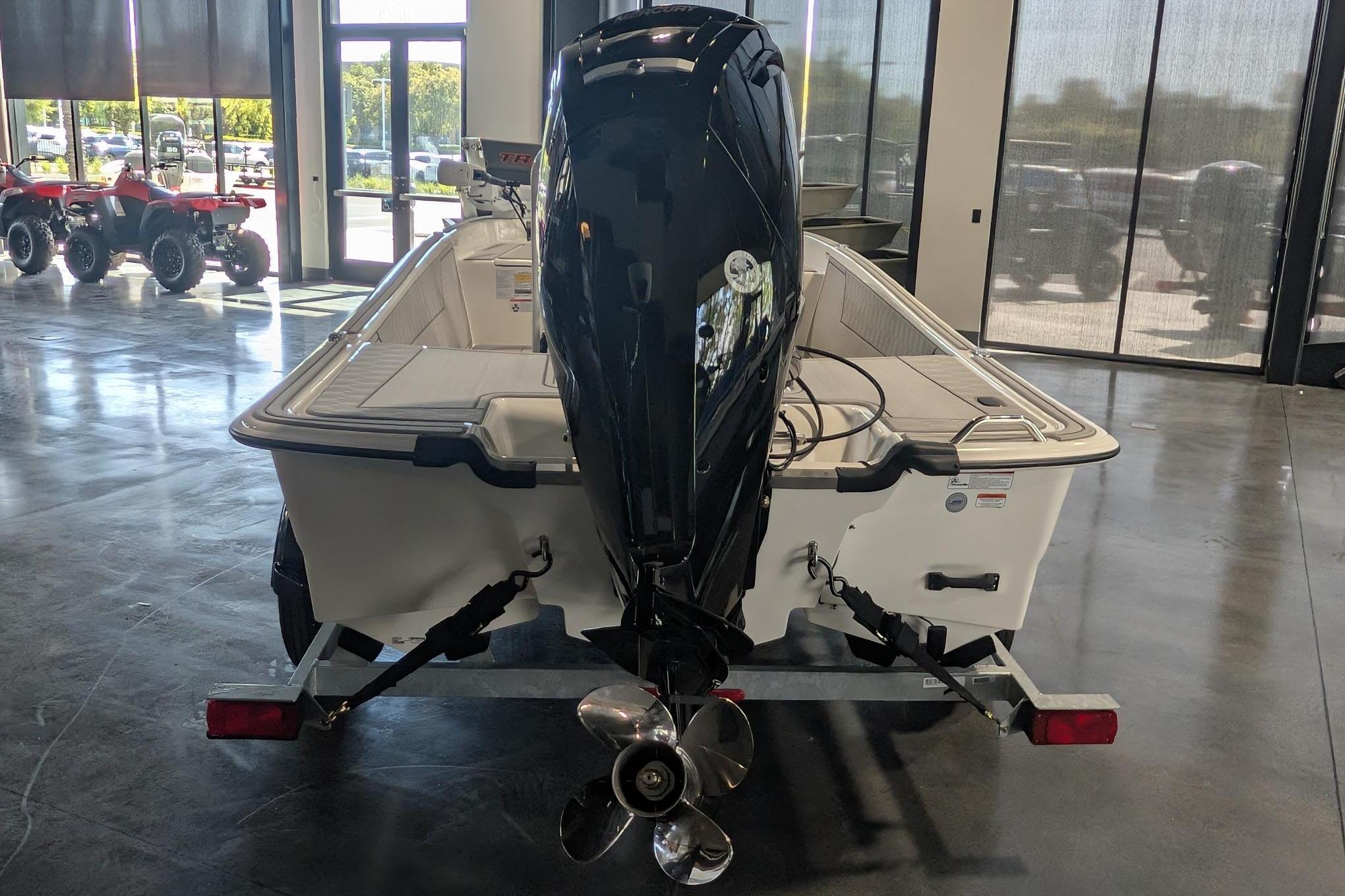 2026 Mako Pro Skiff 17 CC boat with outboard motor in showroom.