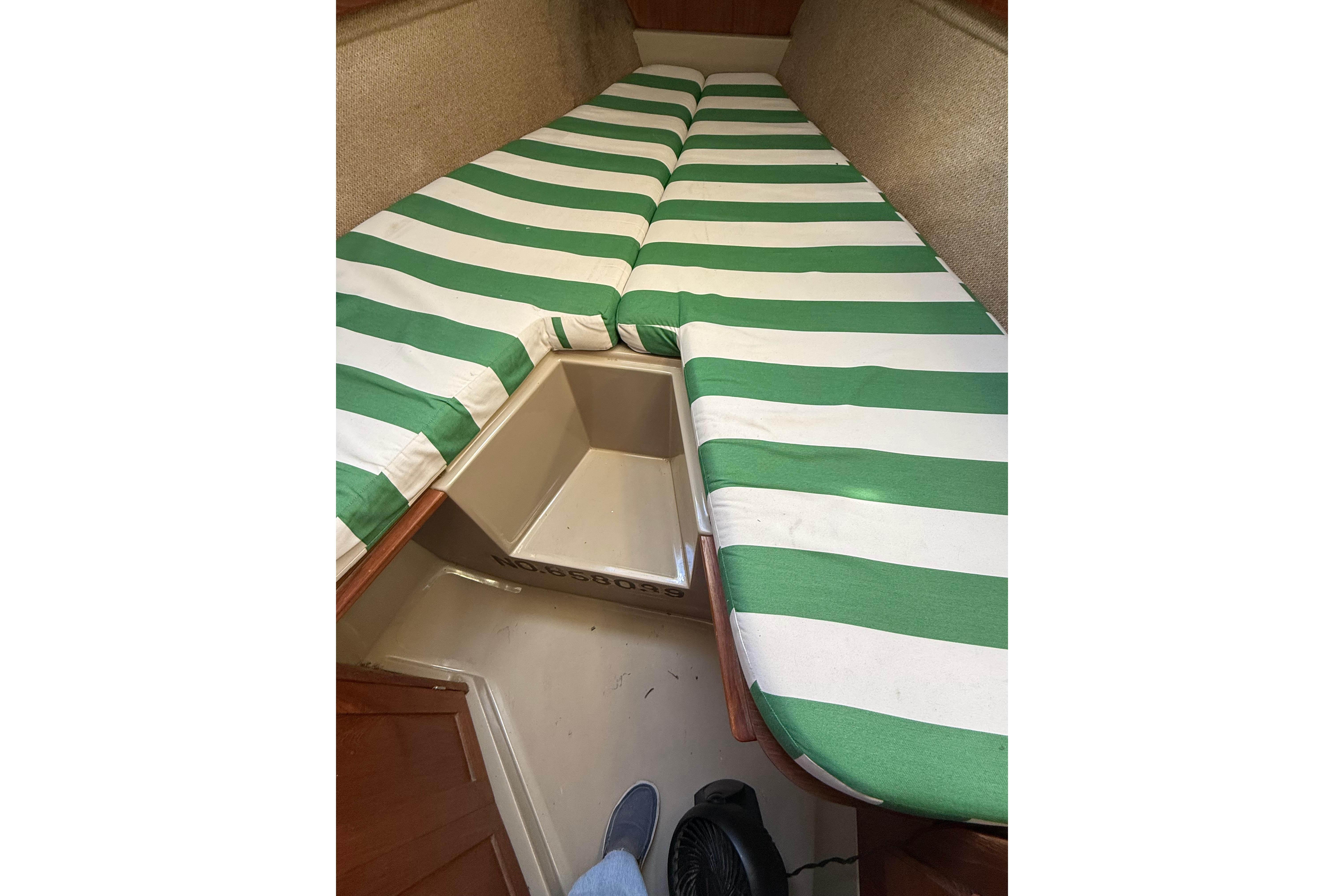 Interior of 1983 O'Day 34 sailboat with green-striped cushions in cabin.