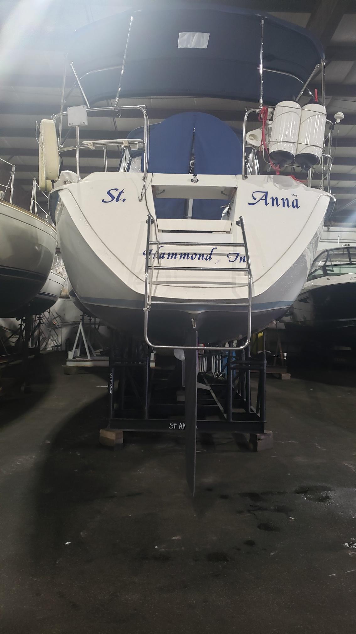 1989 Hunter Legend 37 sailboat in storage, rear view with ladder and equipment.