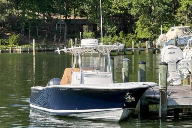 2014 Southport 29 FE boat docked on a serene lake with lush greenery.