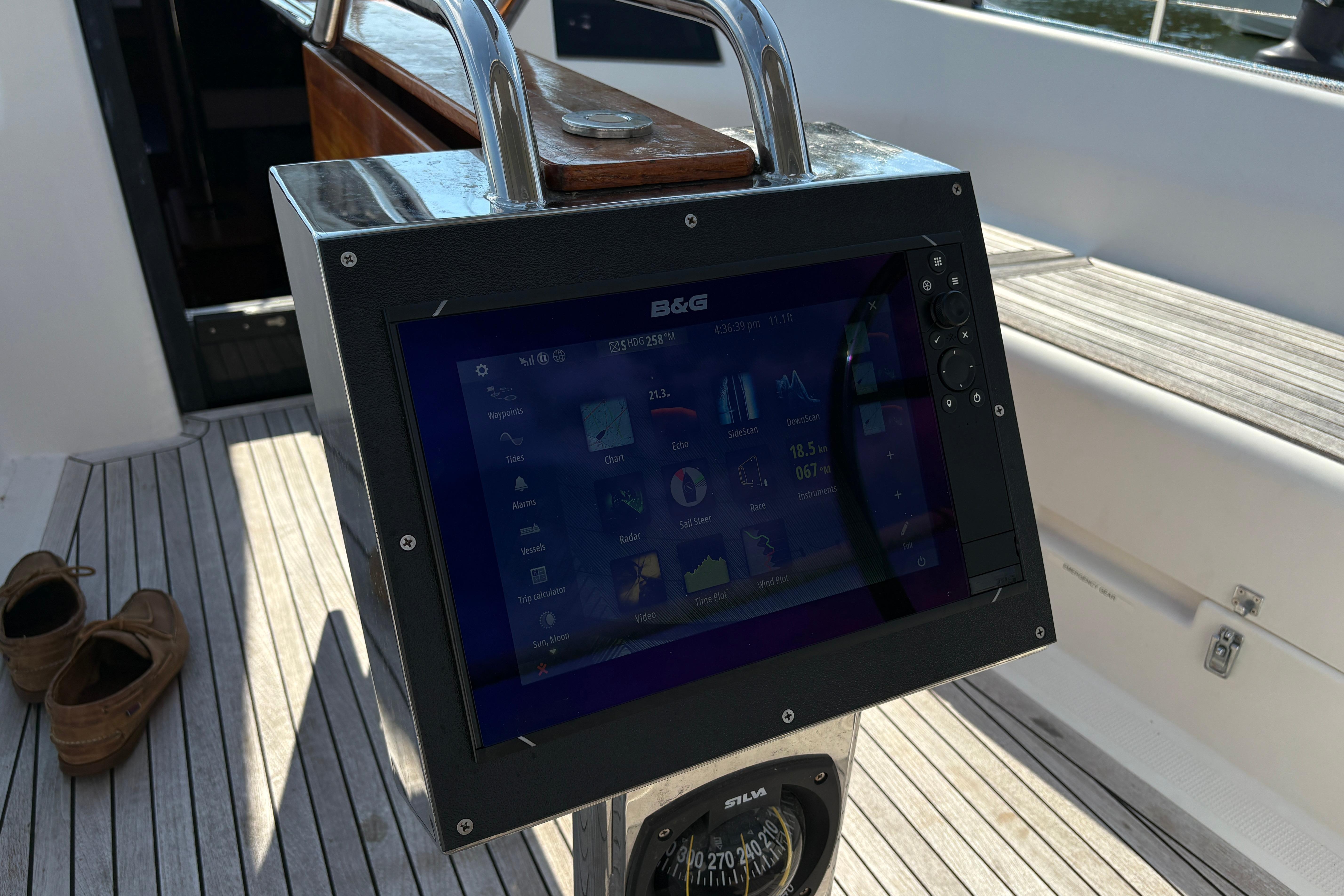 B&G navigation display on 2014 Hanse 415 yacht, with wooden deck and shoes nearby.