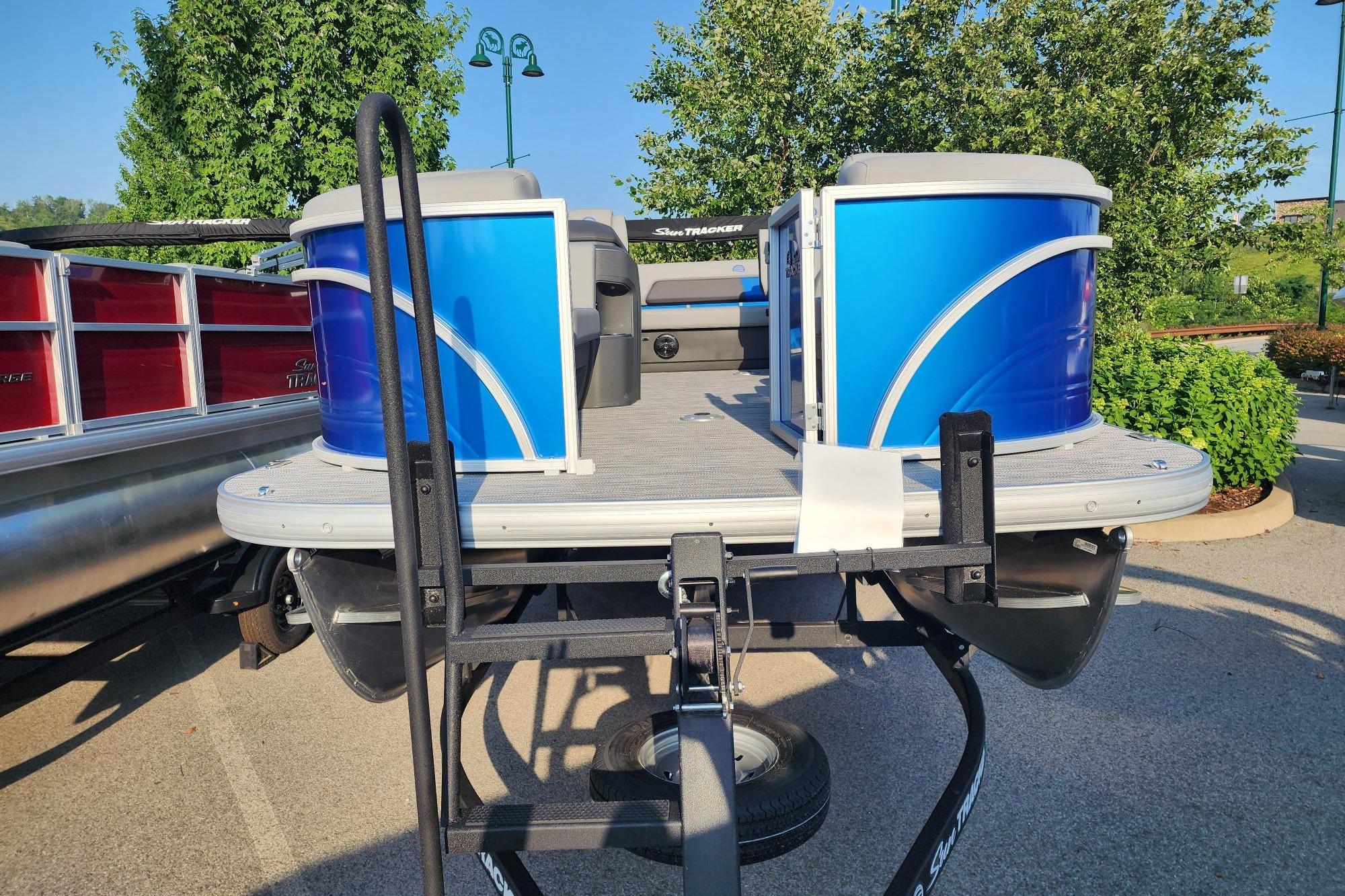 2026 Sun Tracker Party Barge 22 RF DLX pontoon boat on trailer, parked outdoors.