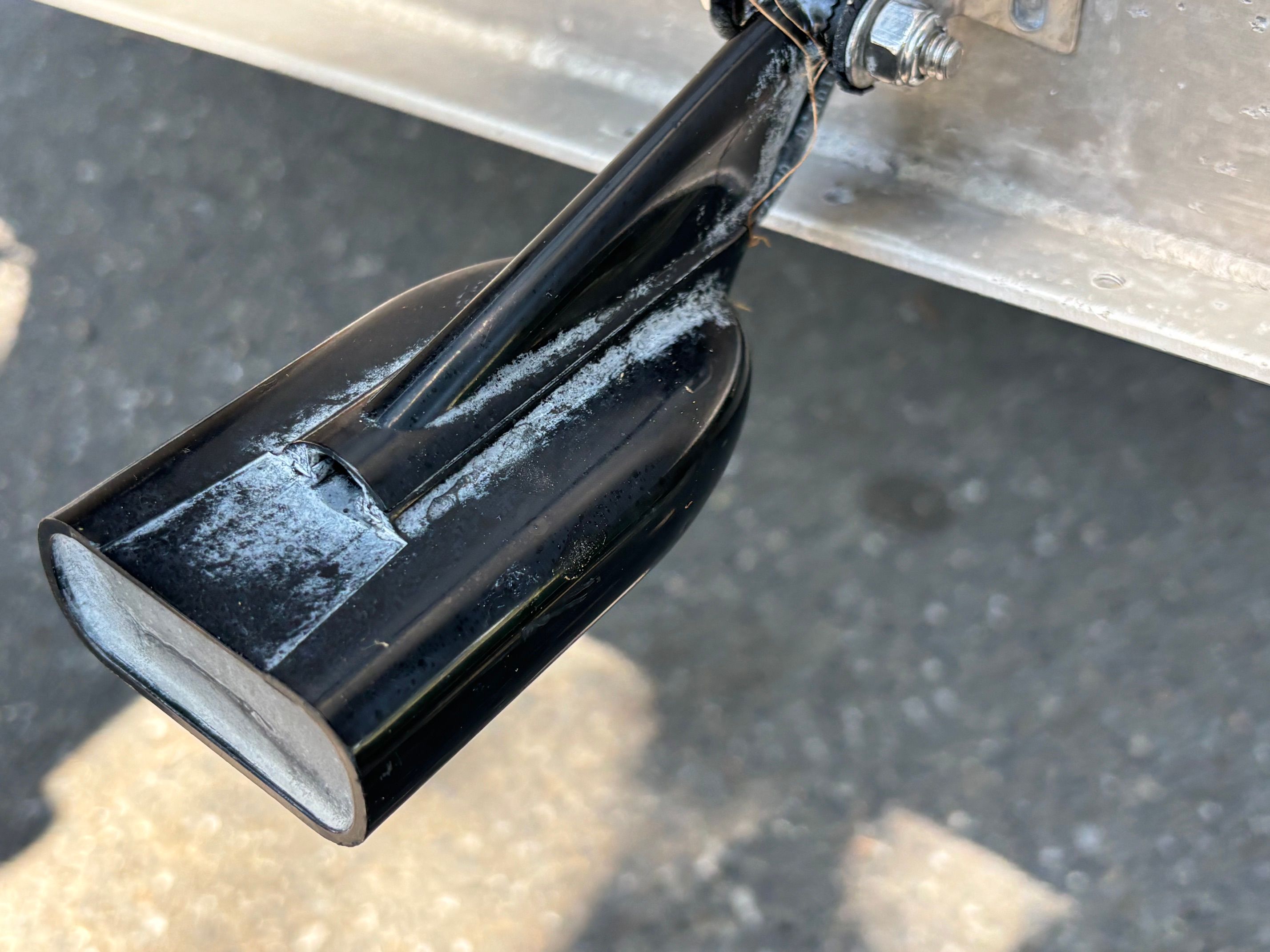 Close-up of a black boat propeller with signs of wear.