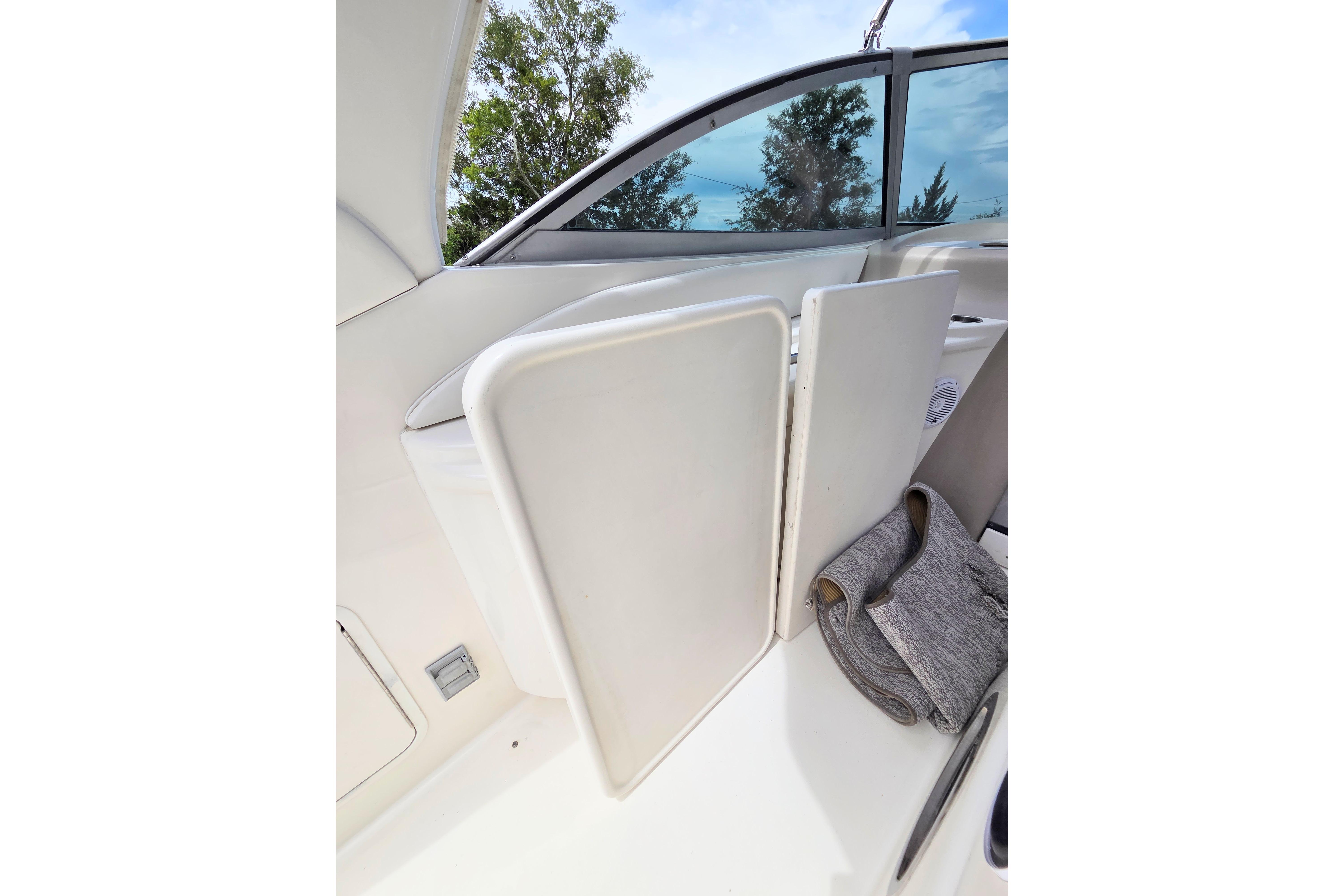 Interior view of a 2000 Sea Ray 340 Sundancer boat with folded seat and window.