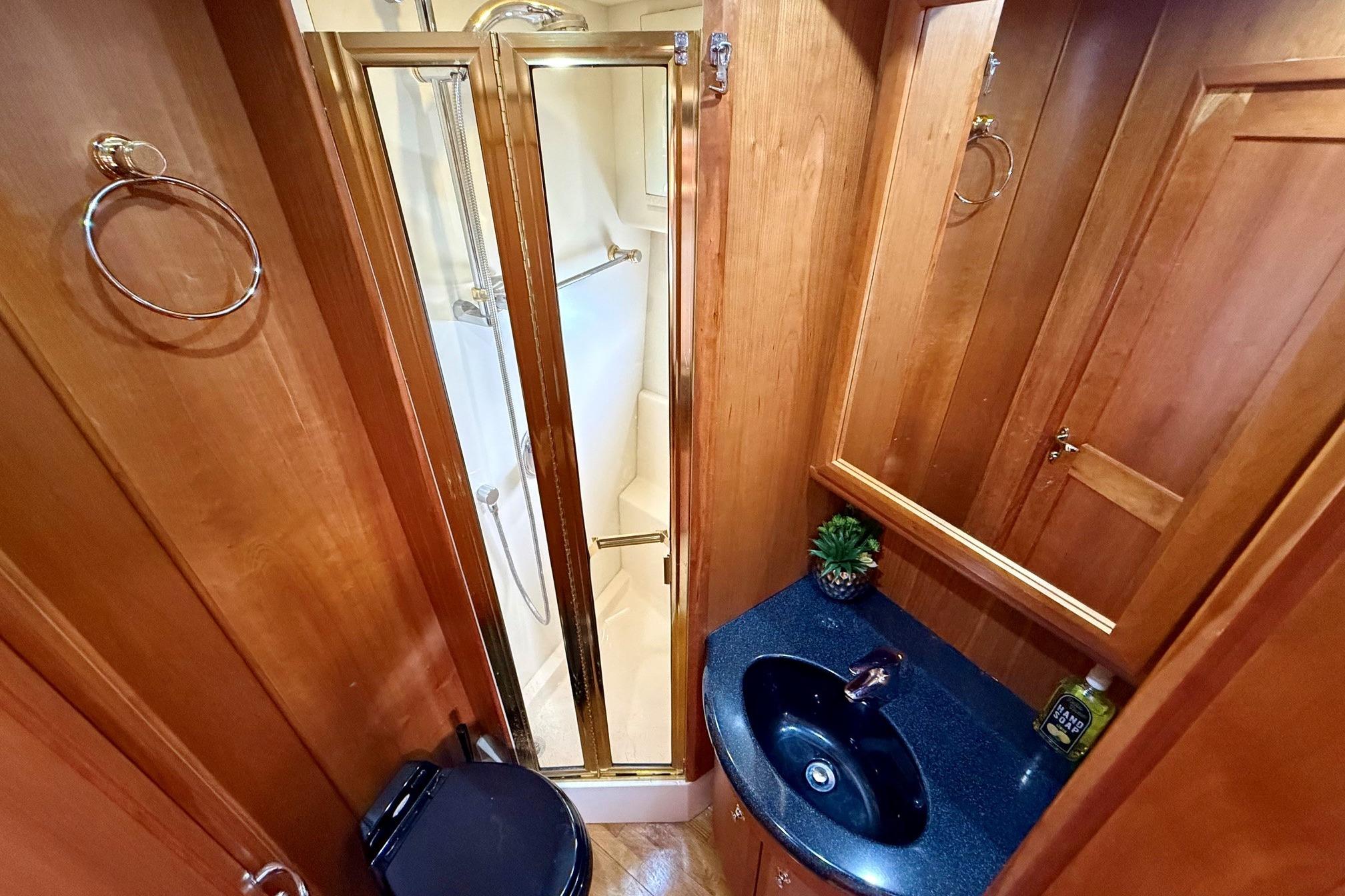 Luxurious bathroom in 2004 Silverton 39 Motor Yacht with wood accents and modern fixtures.