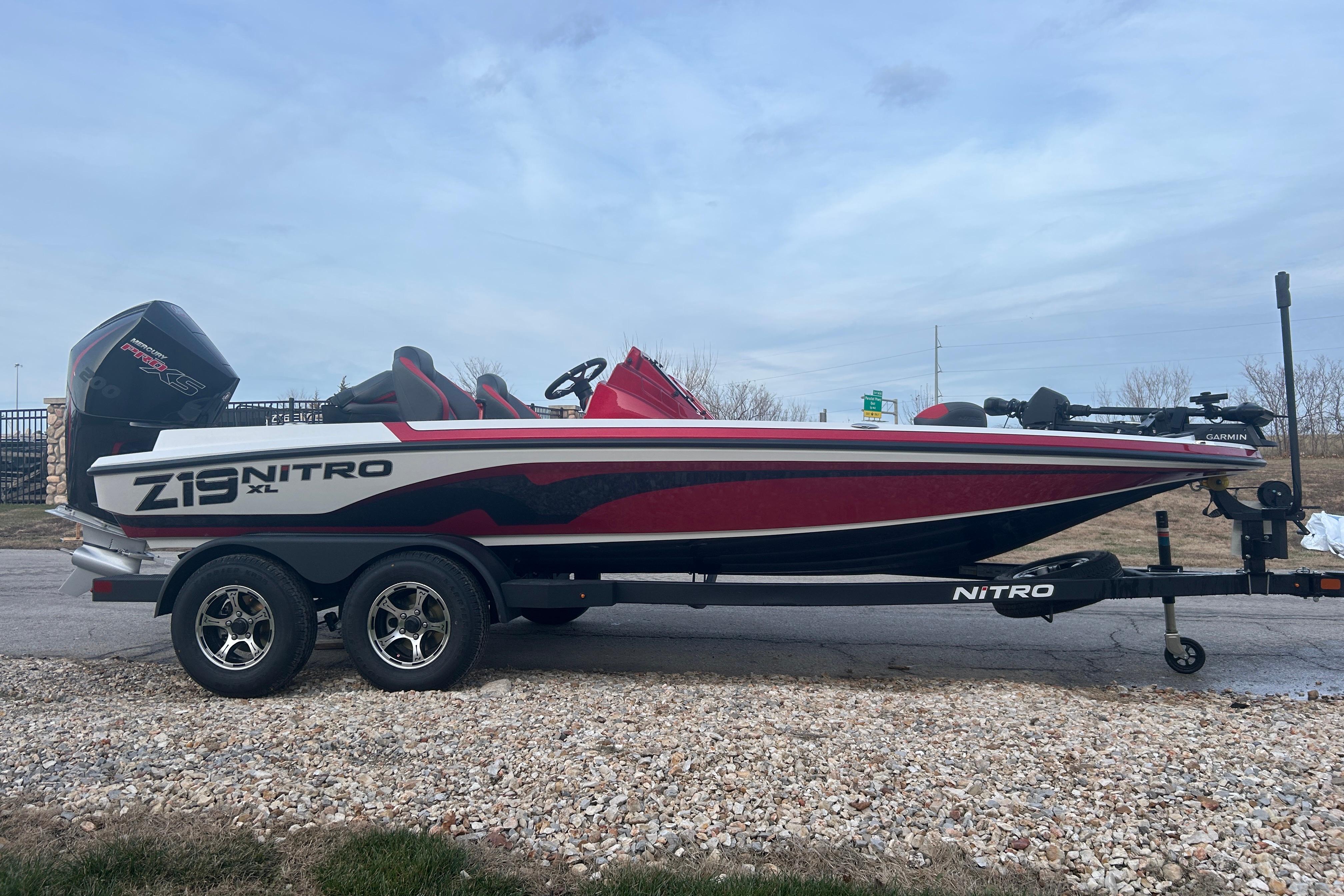 2026 Nitro Z19 XL Pro boat on trailer, red and white design, parked outdoors.