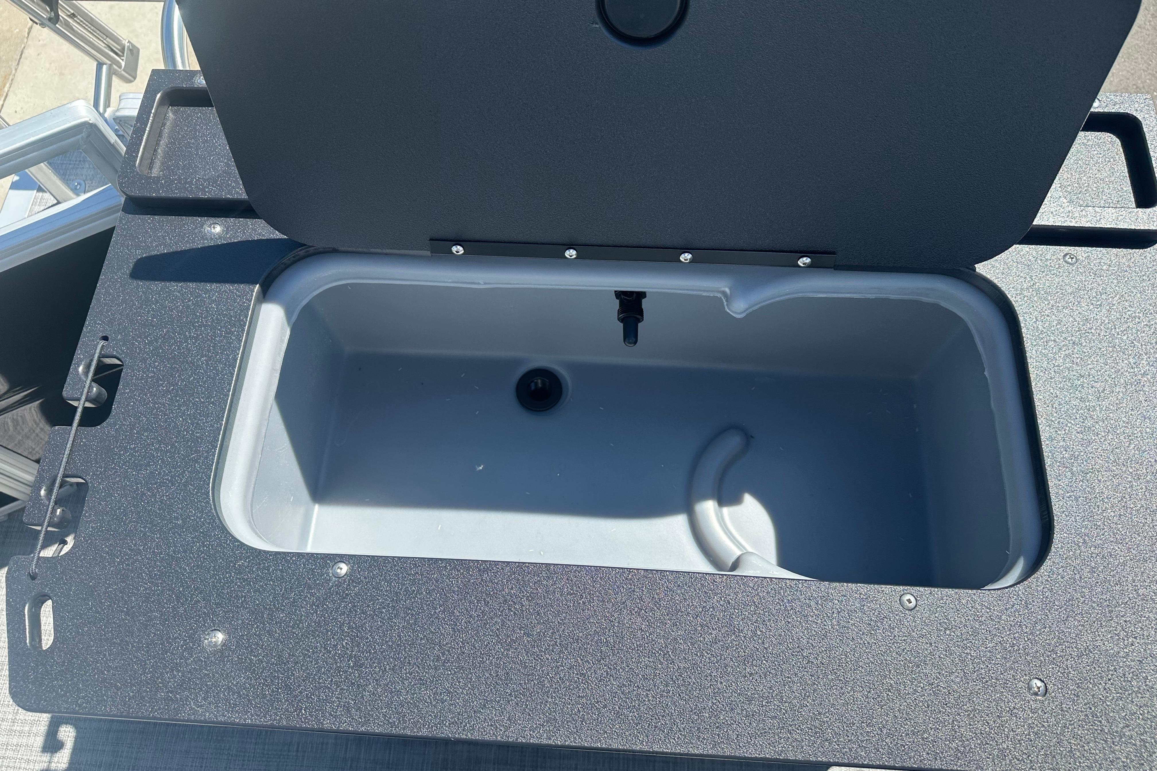 Livewell compartment on 2026 Sun Tracker SportFish 22 DLX boat, open lid view.
