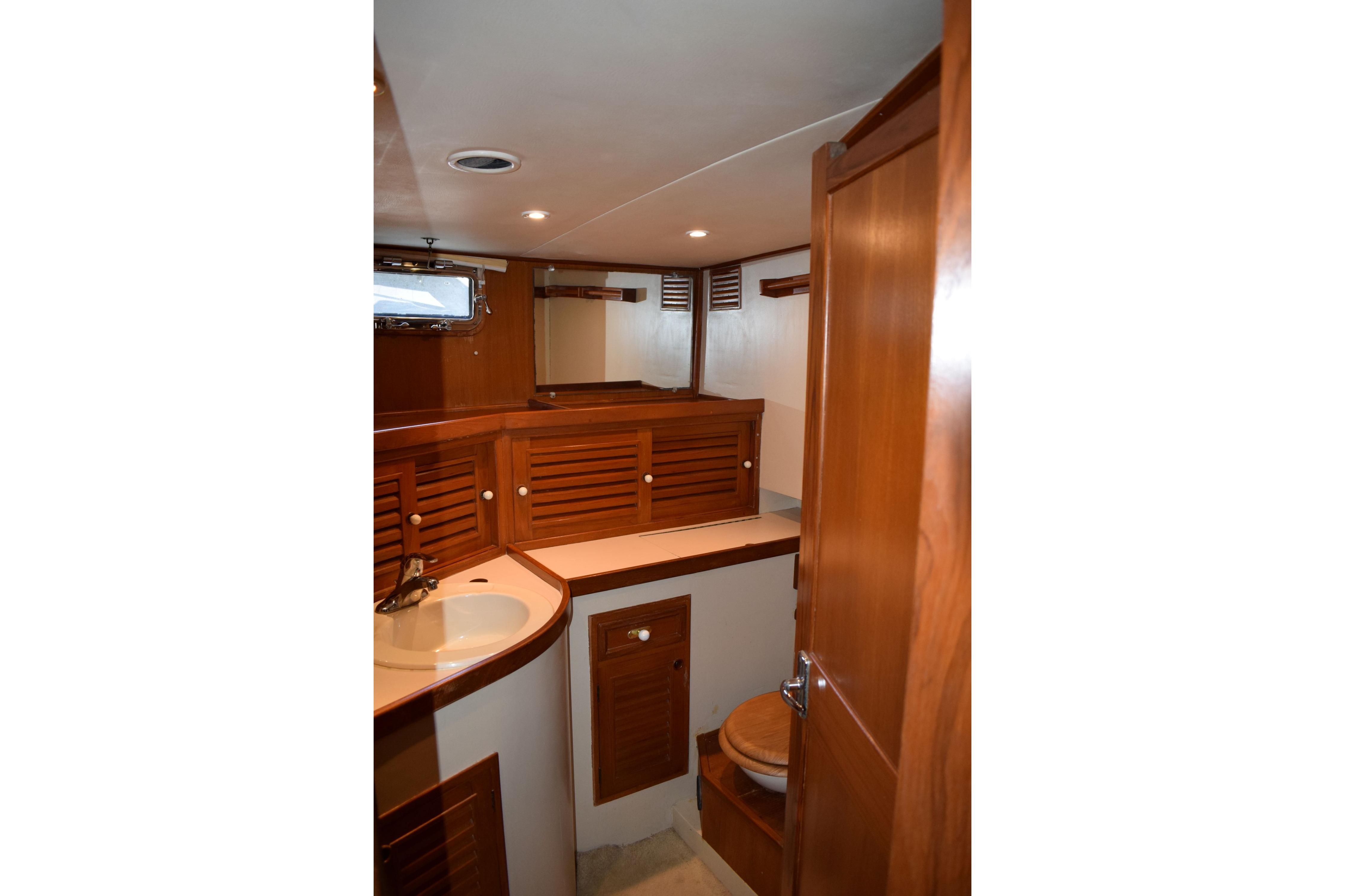 Interior of 1980 Cheoy Lee 52 Motorsailer bathroom with wooden cabinetry and sink.