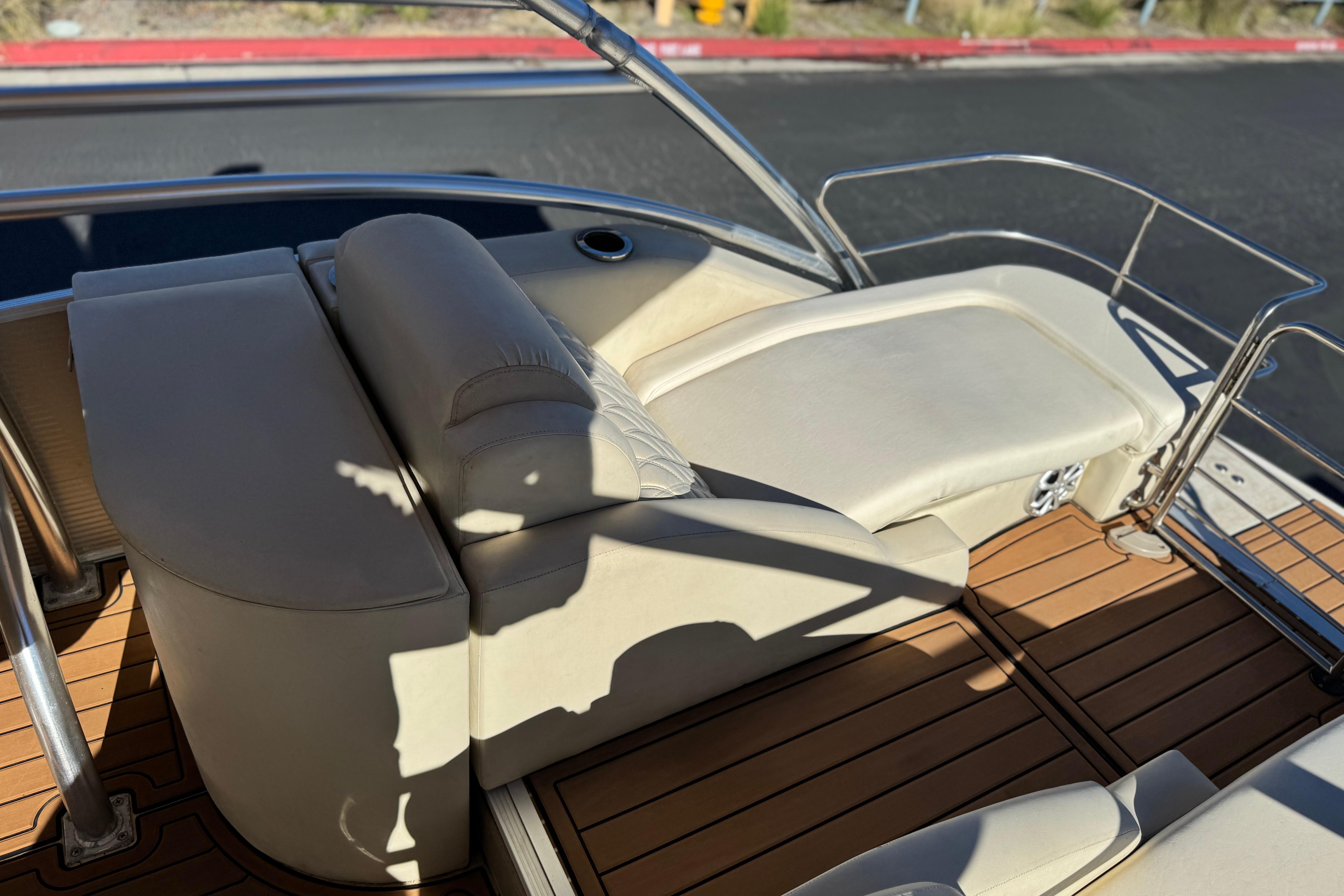 2013 Bennington 2575QCW I/O boat interior with beige seating and wooden deck.