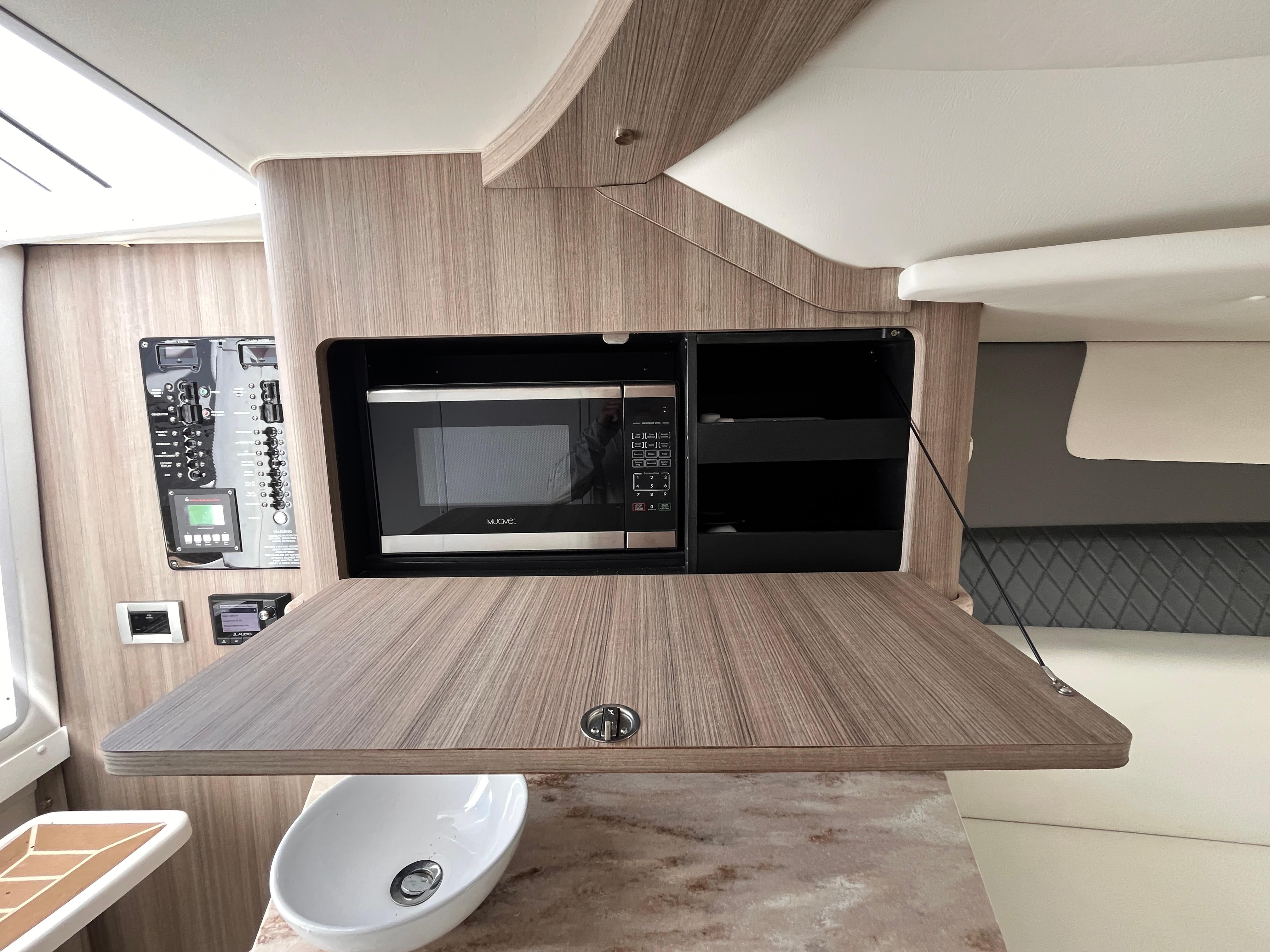 2021 Fountain 38 SFC interior with microwave, wooden cabinetry, and modern design elements.
