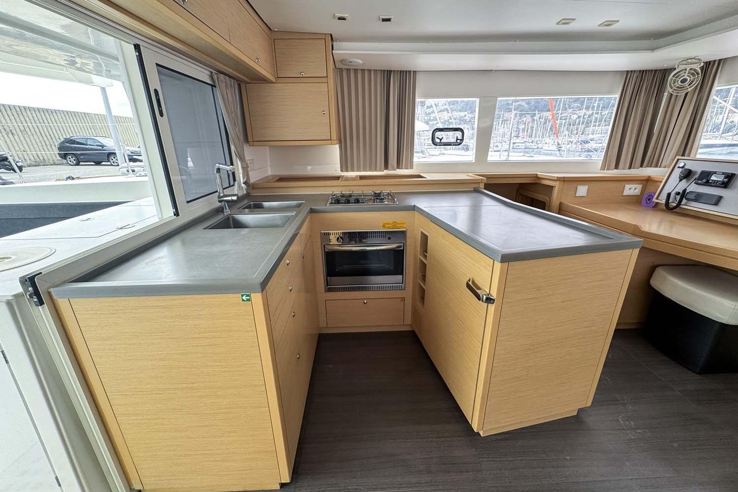 Modern kitchen interior of 2019 Lagoon 450 F catamaran with wood cabinetry and appliances.