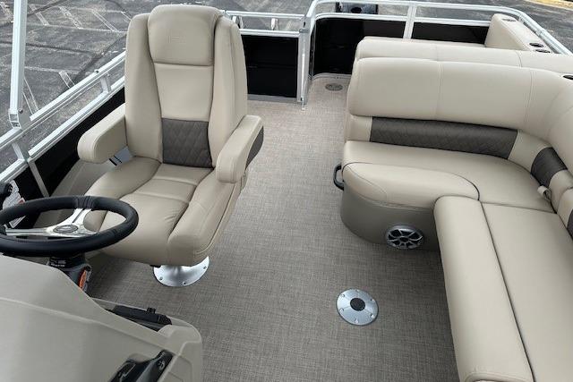 2025 Sun Tracker Sportfish 24 XP3 interior with beige seating and steering wheel.