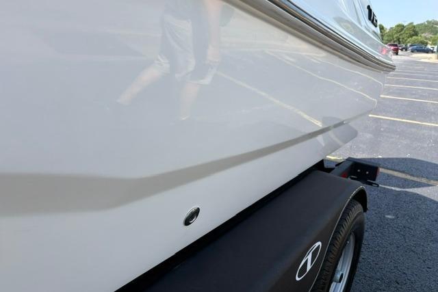 2024 Tahoe T21 boat on trailer, side view in parking lot.