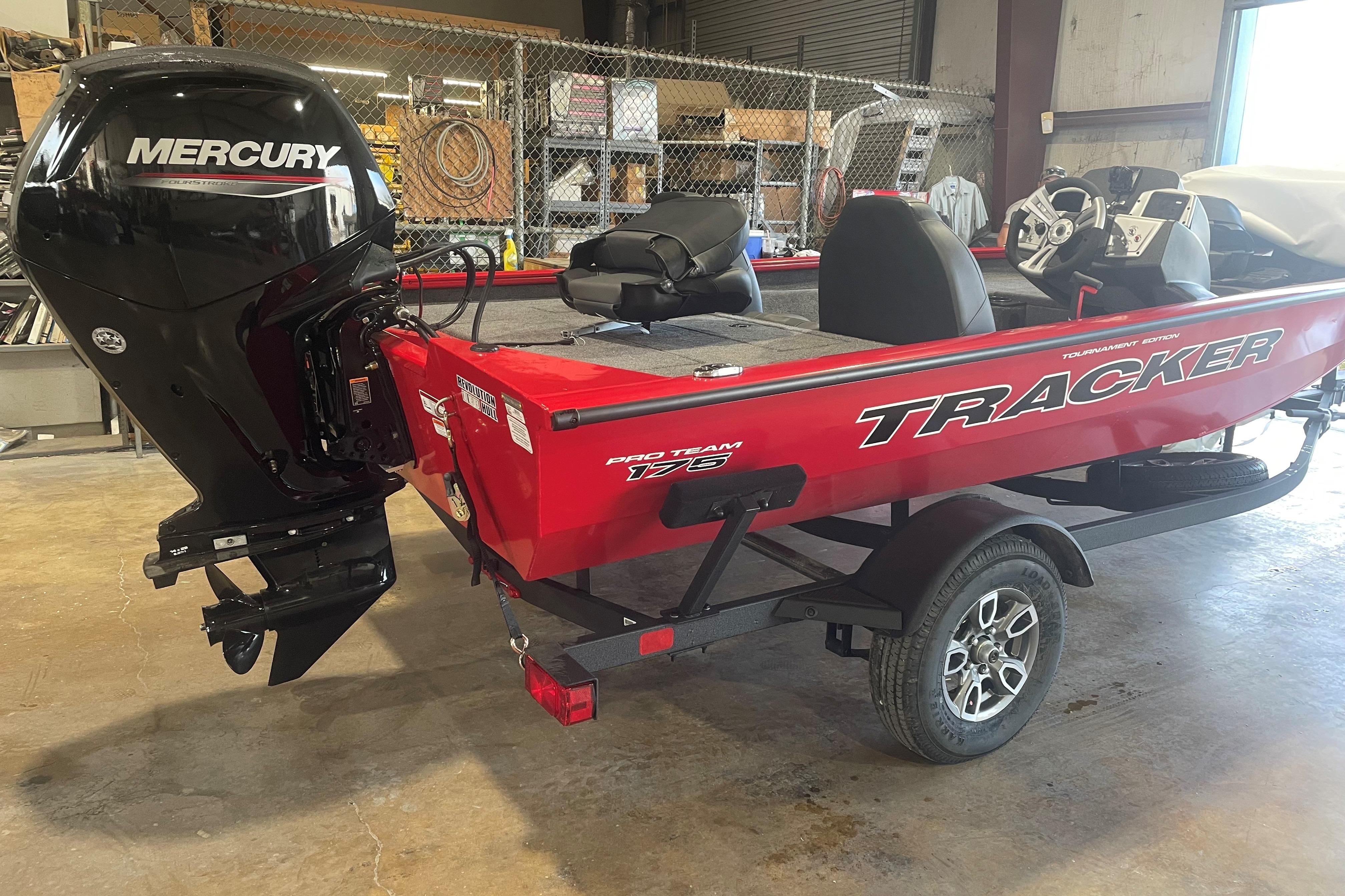 2026 Tracker Pro Team 175 boat with Mercury engine in a garage setting.