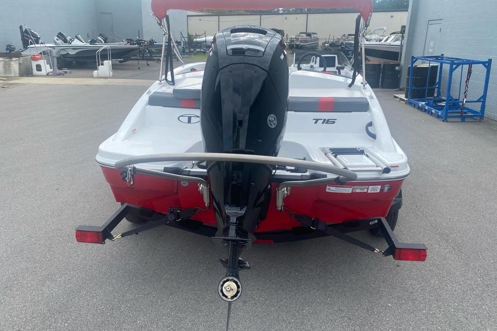 2026 Tahoe T16 boat with outboard motor, red and white design, parked on trailer.