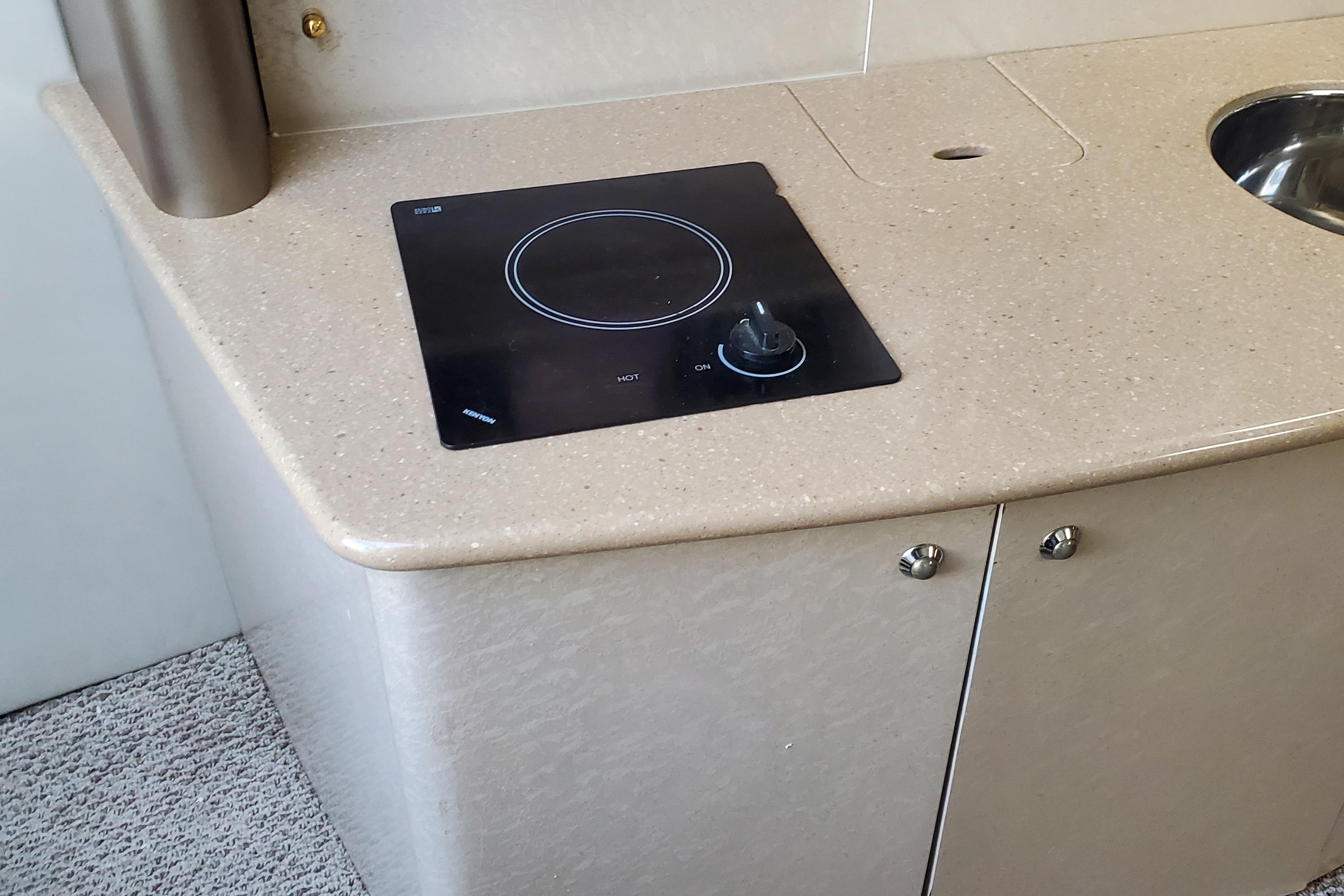 2004 Formula 370 Super Sport boat interior kitchen with stovetop and sink.