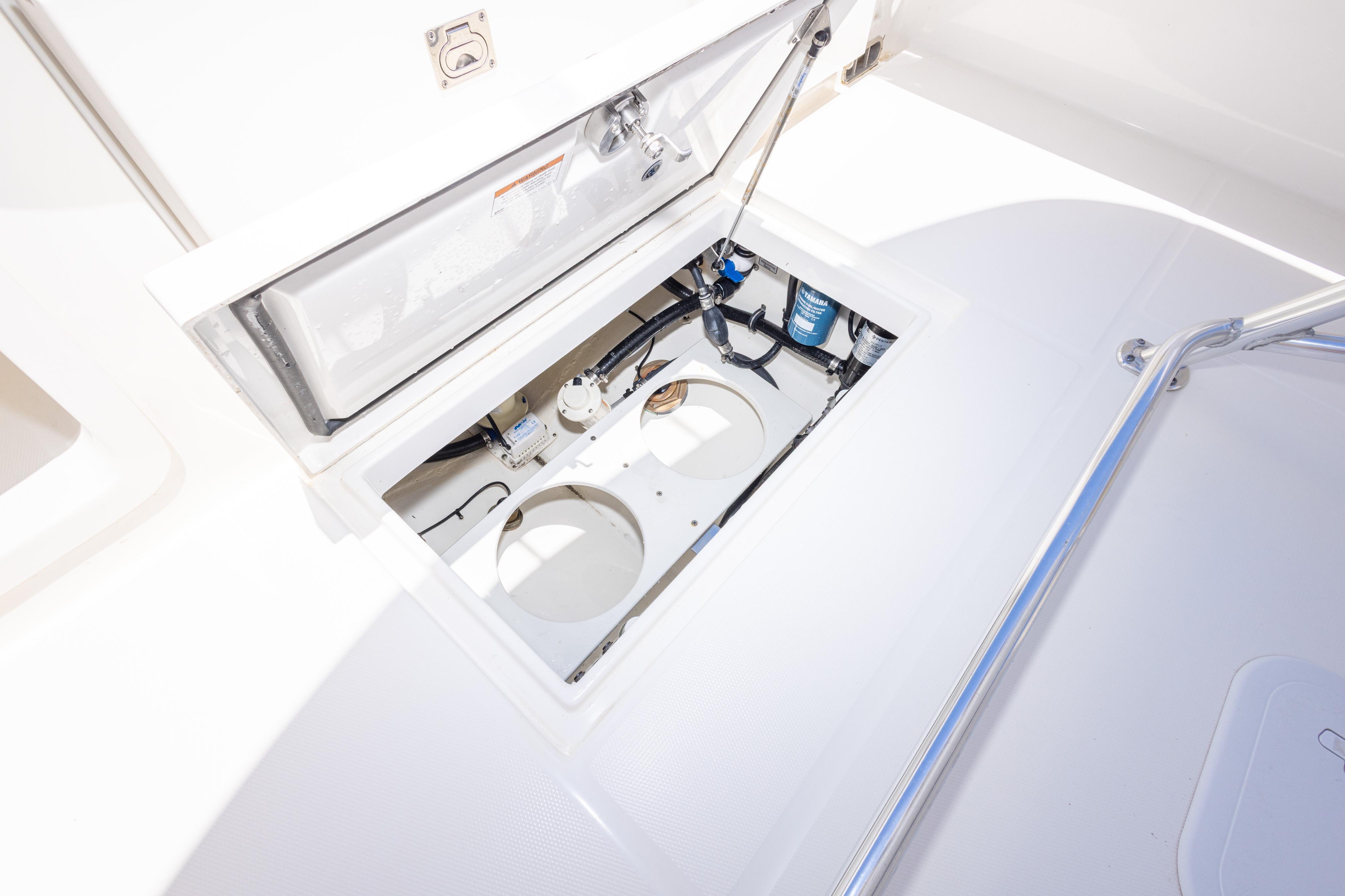 Open hatch on 2019 Regulator 23 Center Console boat, revealing storage compartment.
