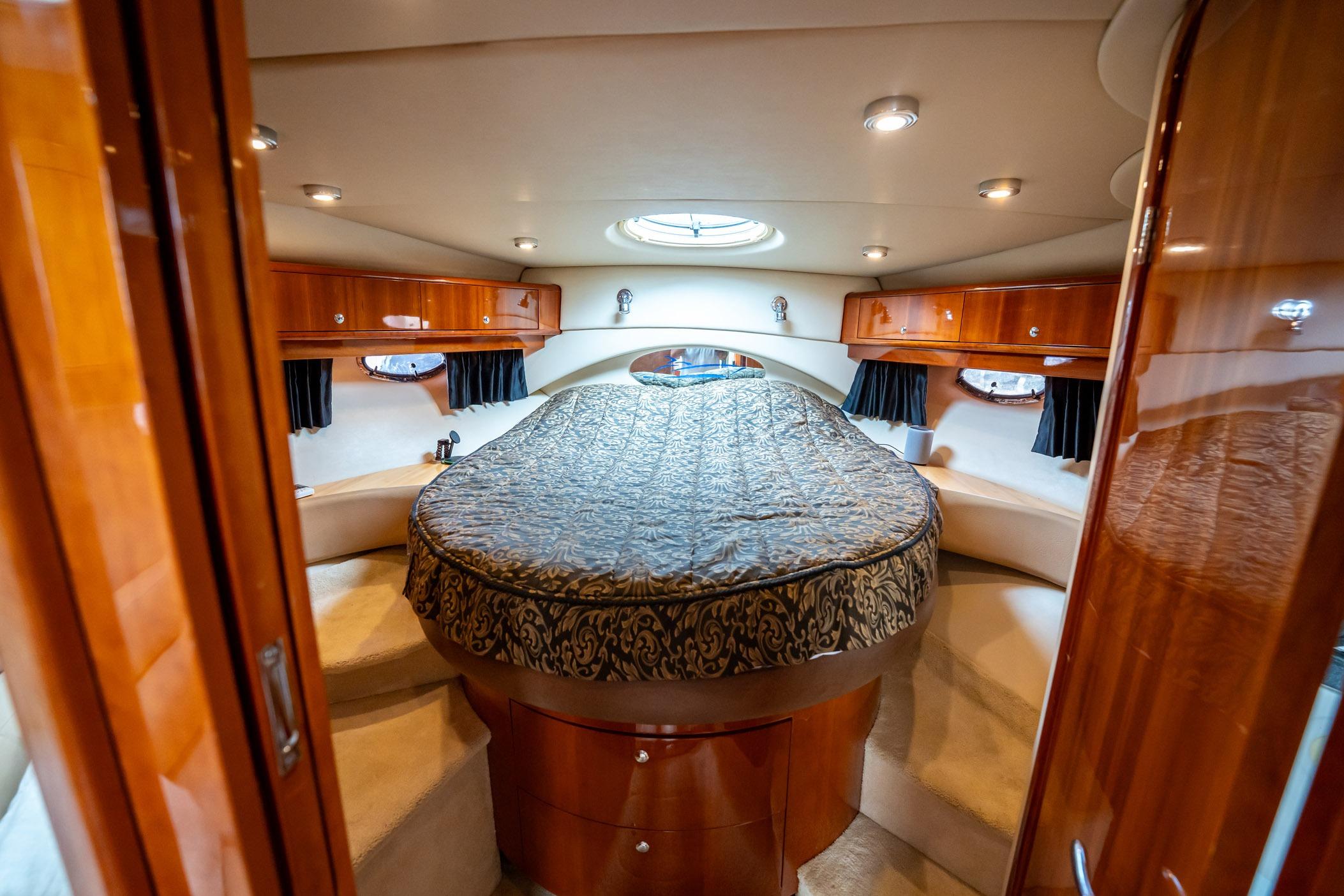 Luxurious cabin interior of 2008 Regal Commodore 4460 yacht with elegant wood finishes.