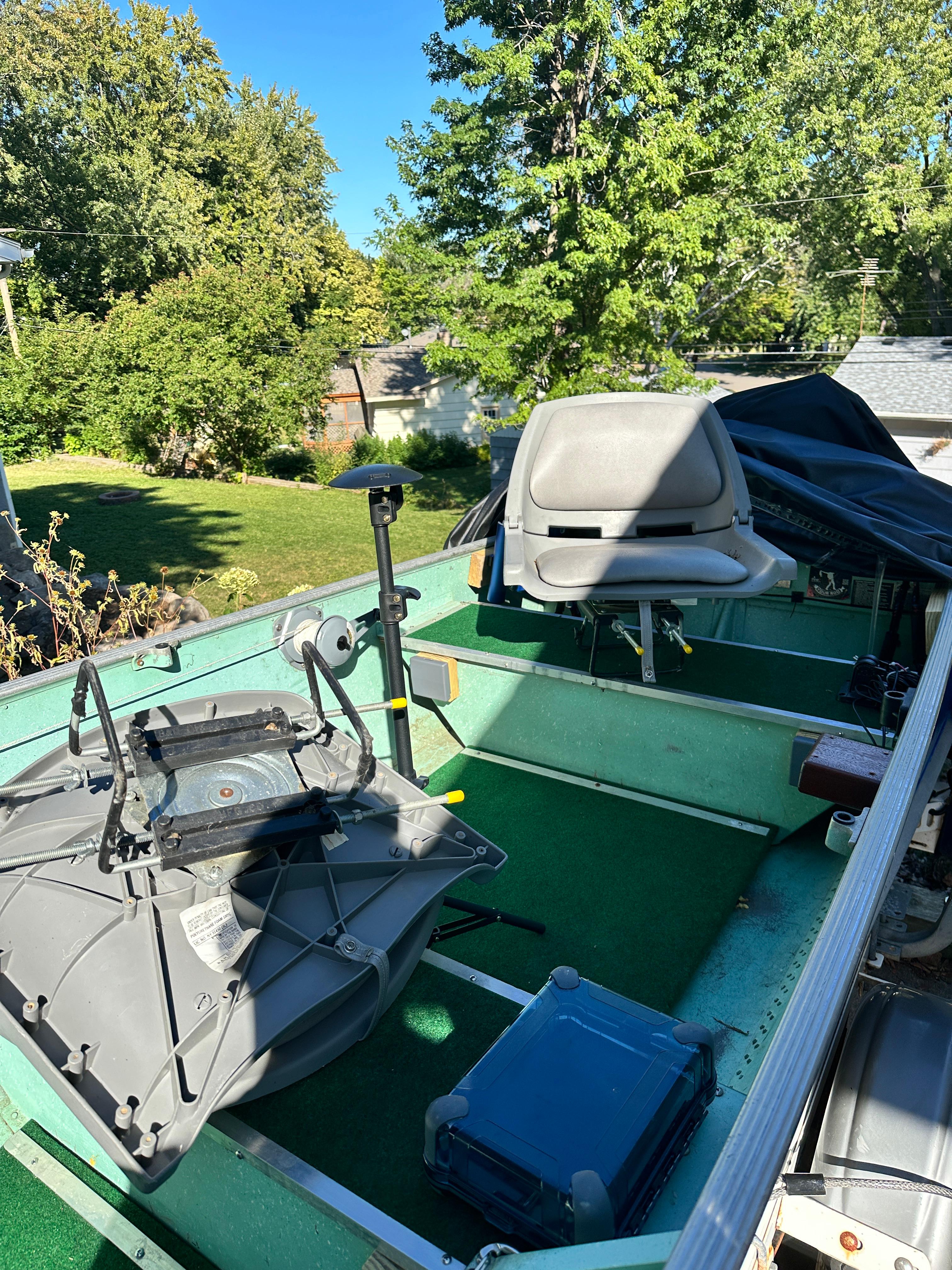 1960 Lund H boat interior with seats and equipment, set in a sunny backyard.