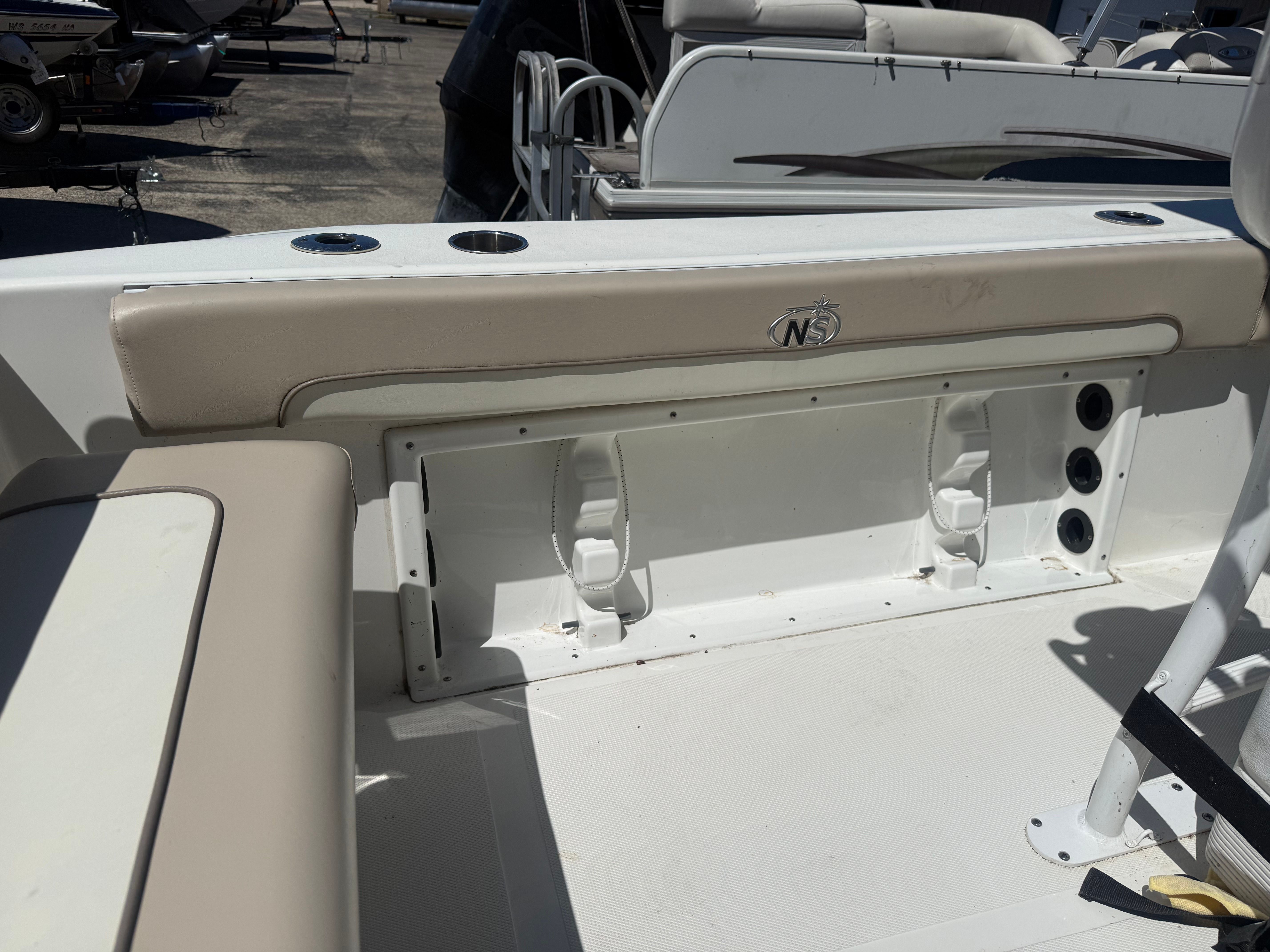 The boat features beige upholstery and cup holders on the rear seating area.
