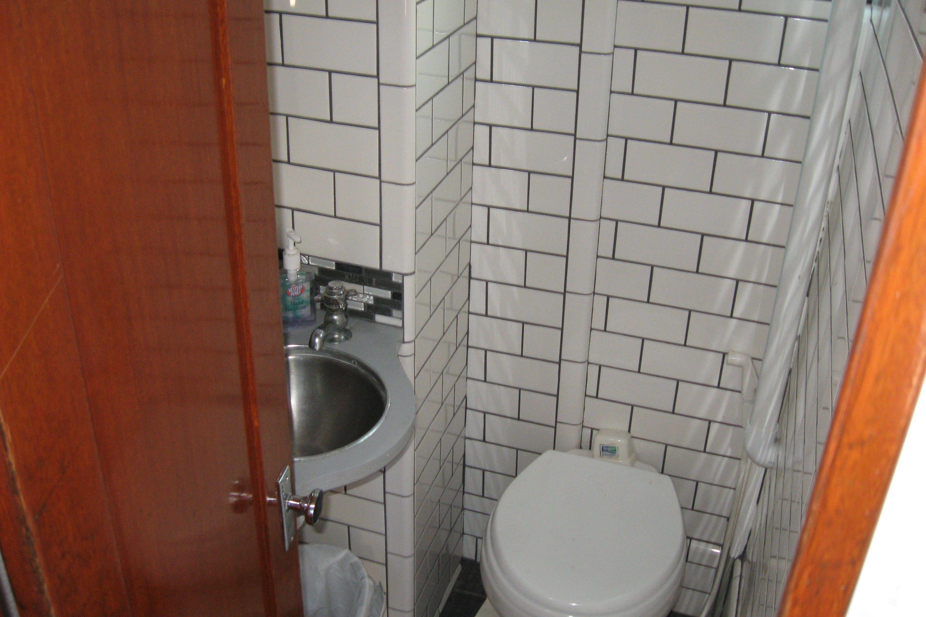 Compact bathroom with white subway tiles on a 1964 Grandy Tour Boat.