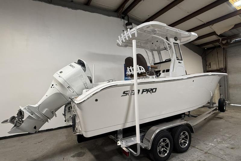 2026 Sea Pro 242 Center Console boat on trailer in warehouse setting.