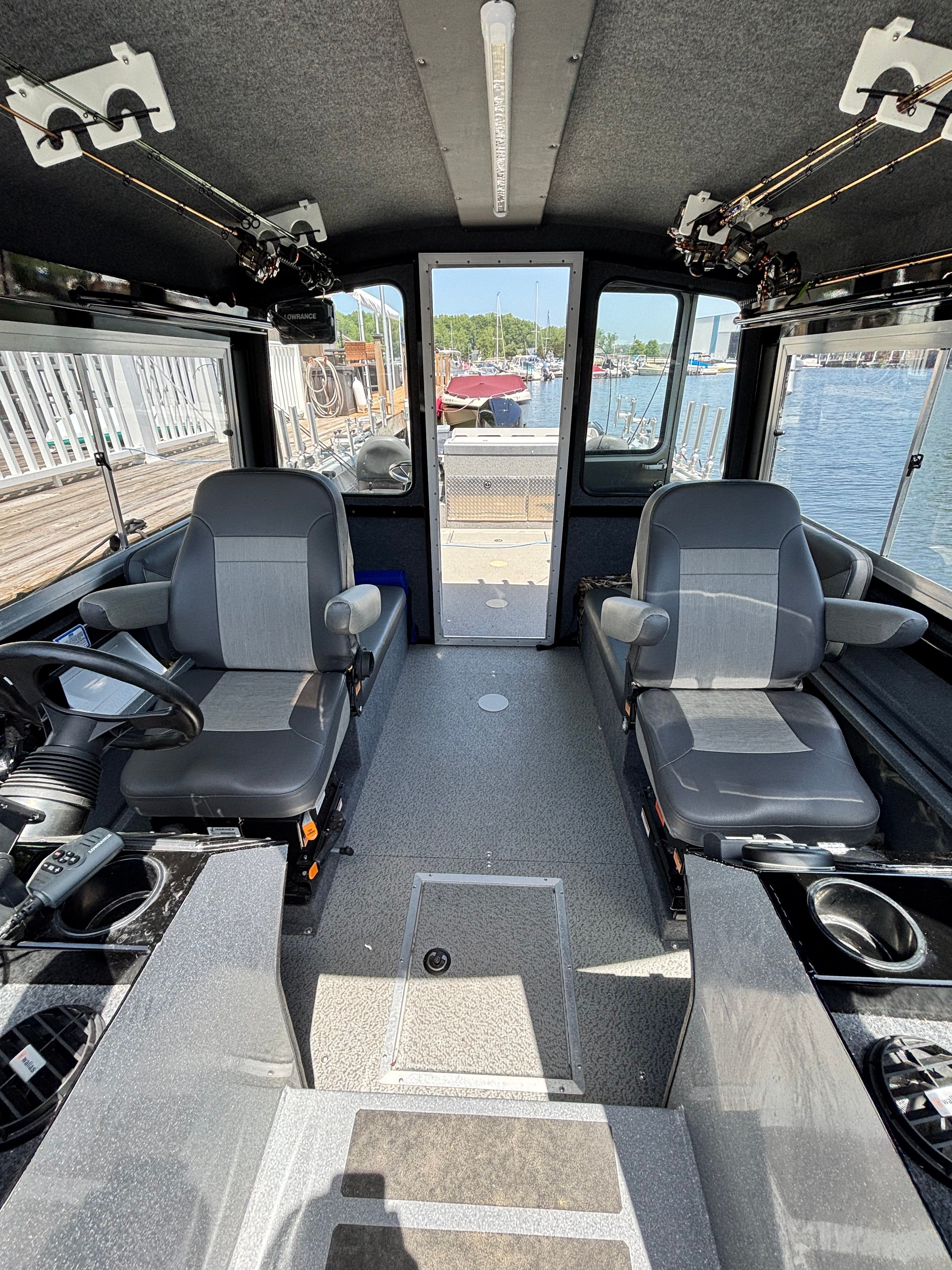 Interior of a 2021 Spartan 240 Maximus with two gray seats and a view of the harbor.