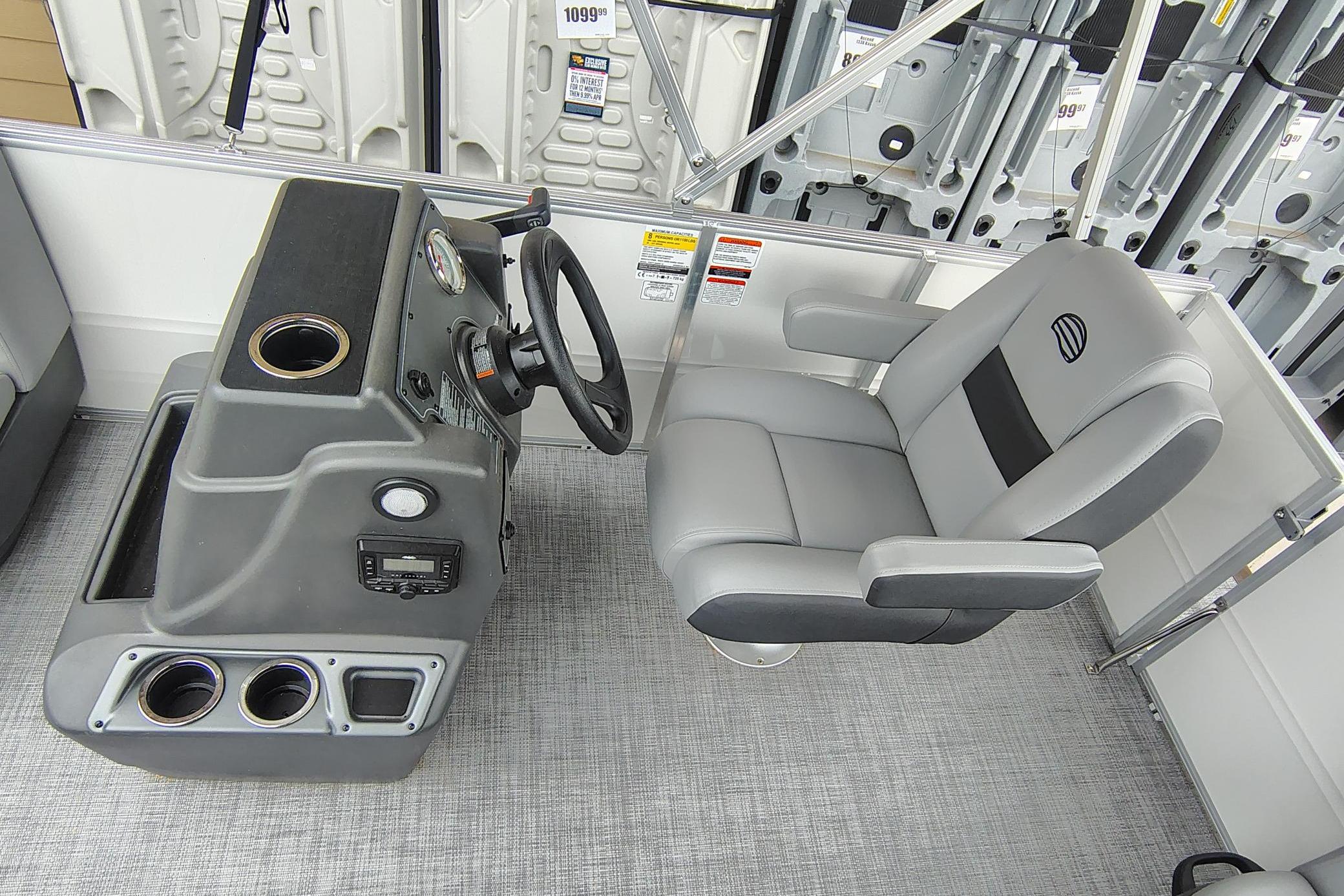 2026 Sun Tracker Party Barge 16 DLX helm with steering wheel and captain's chair.