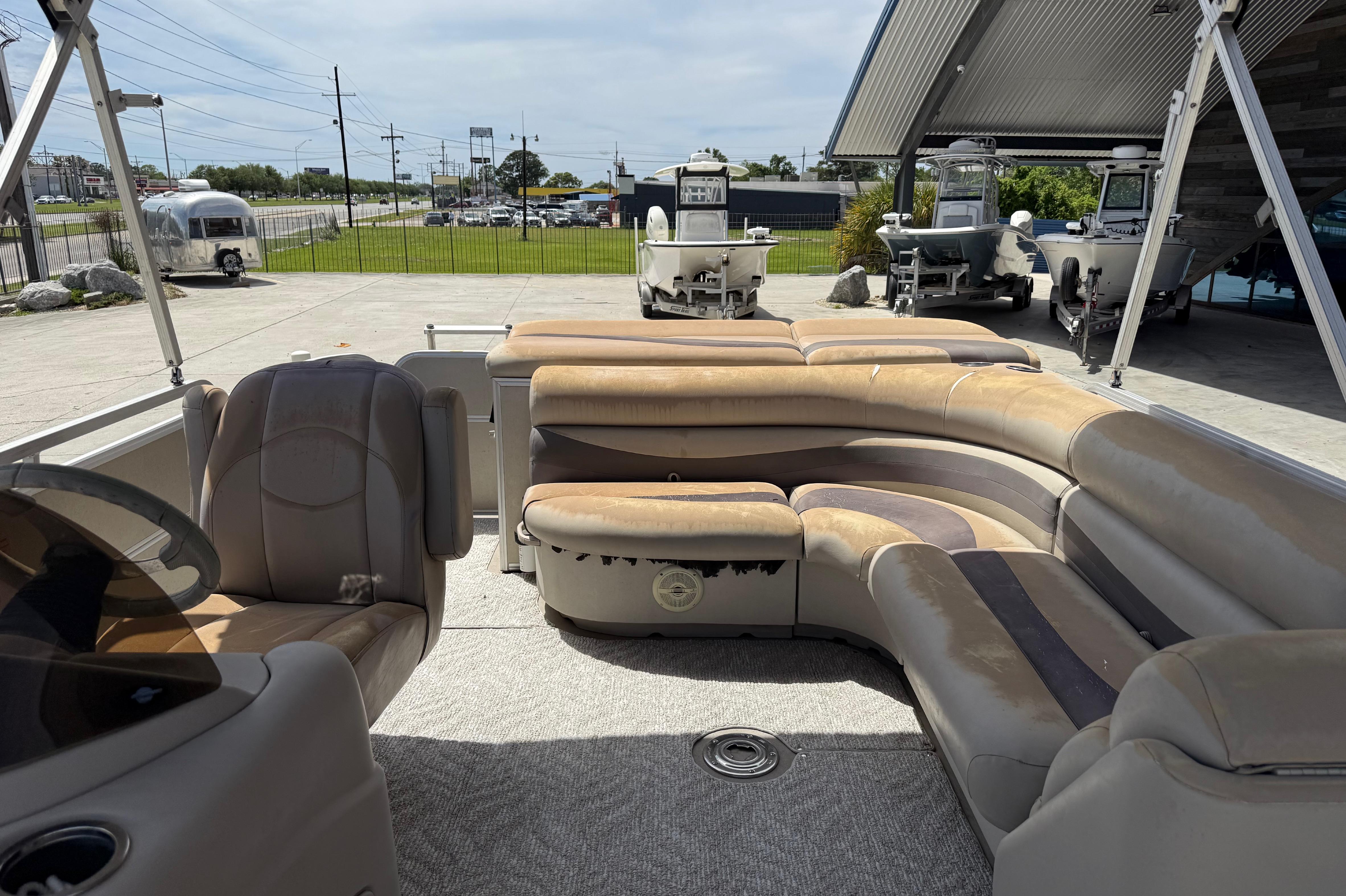 2012 South Bay 522 CR pontoon boat interior with beige seating and steering console.