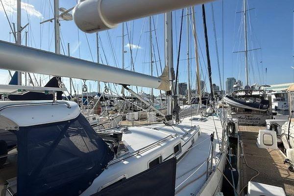 Sailboats docked at a marina, featuring a 2011 Reliance 44 model under clear blue skies.