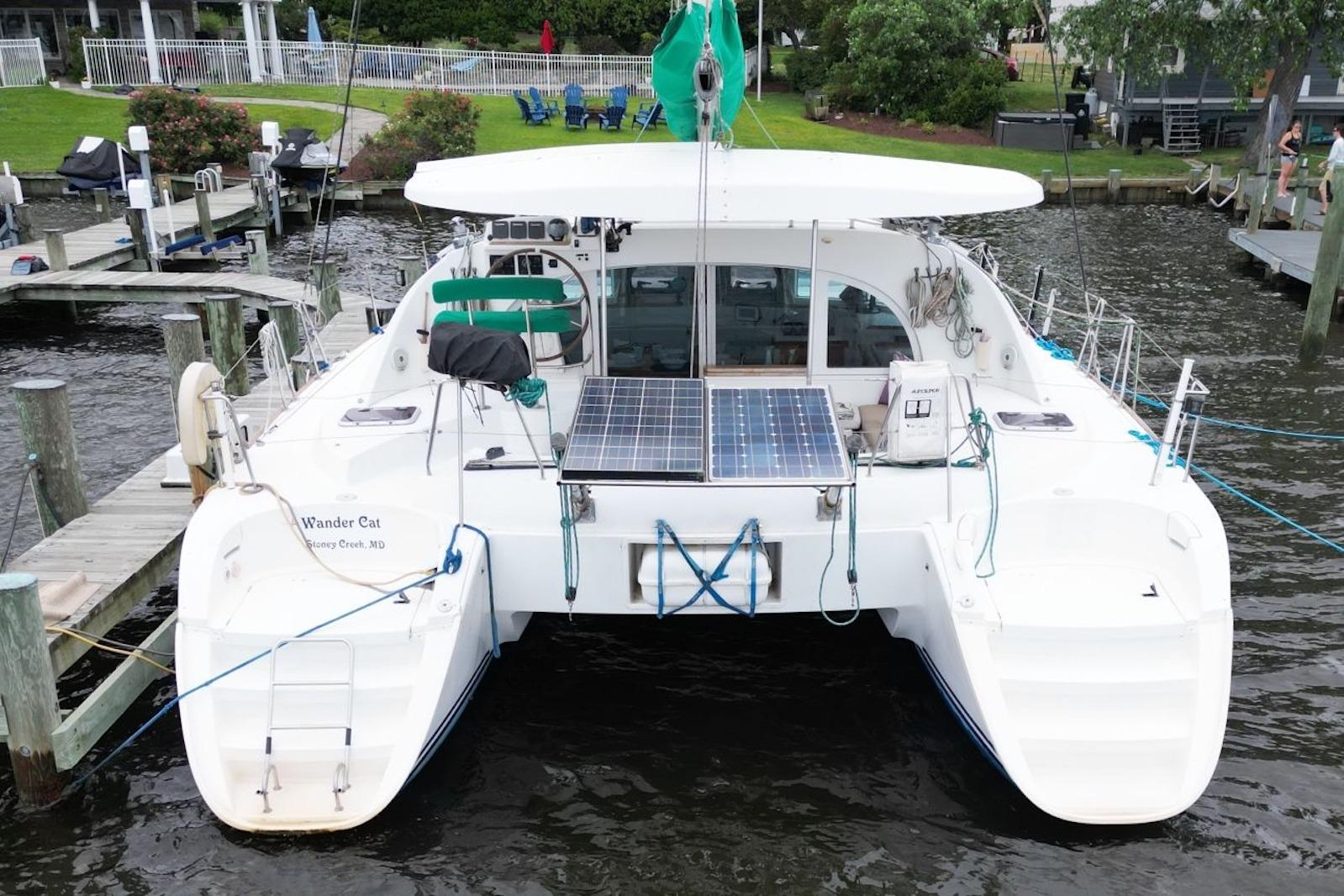 2004 Lagoon 380 catamaran docked, featuring solar panels and spacious deck.