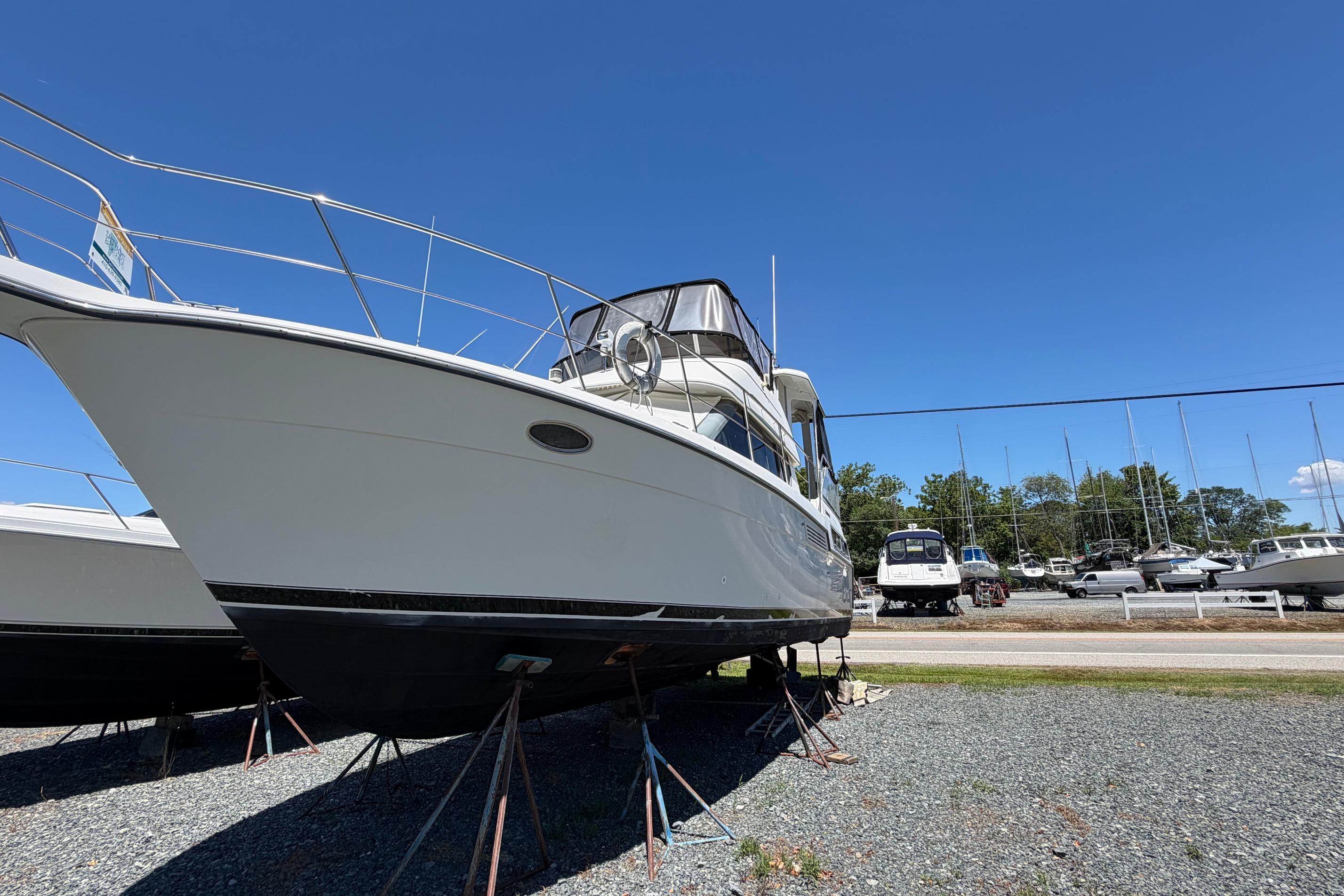 1995 Carver 356 Aft Cabin Motor Yacht on stands, clear blue sky background.