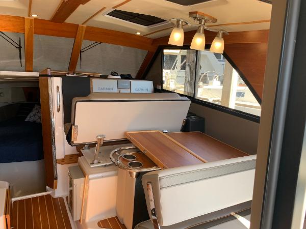 2021 Cutwater C-32 CB interior with dining area, wood accents, and modern lighting.