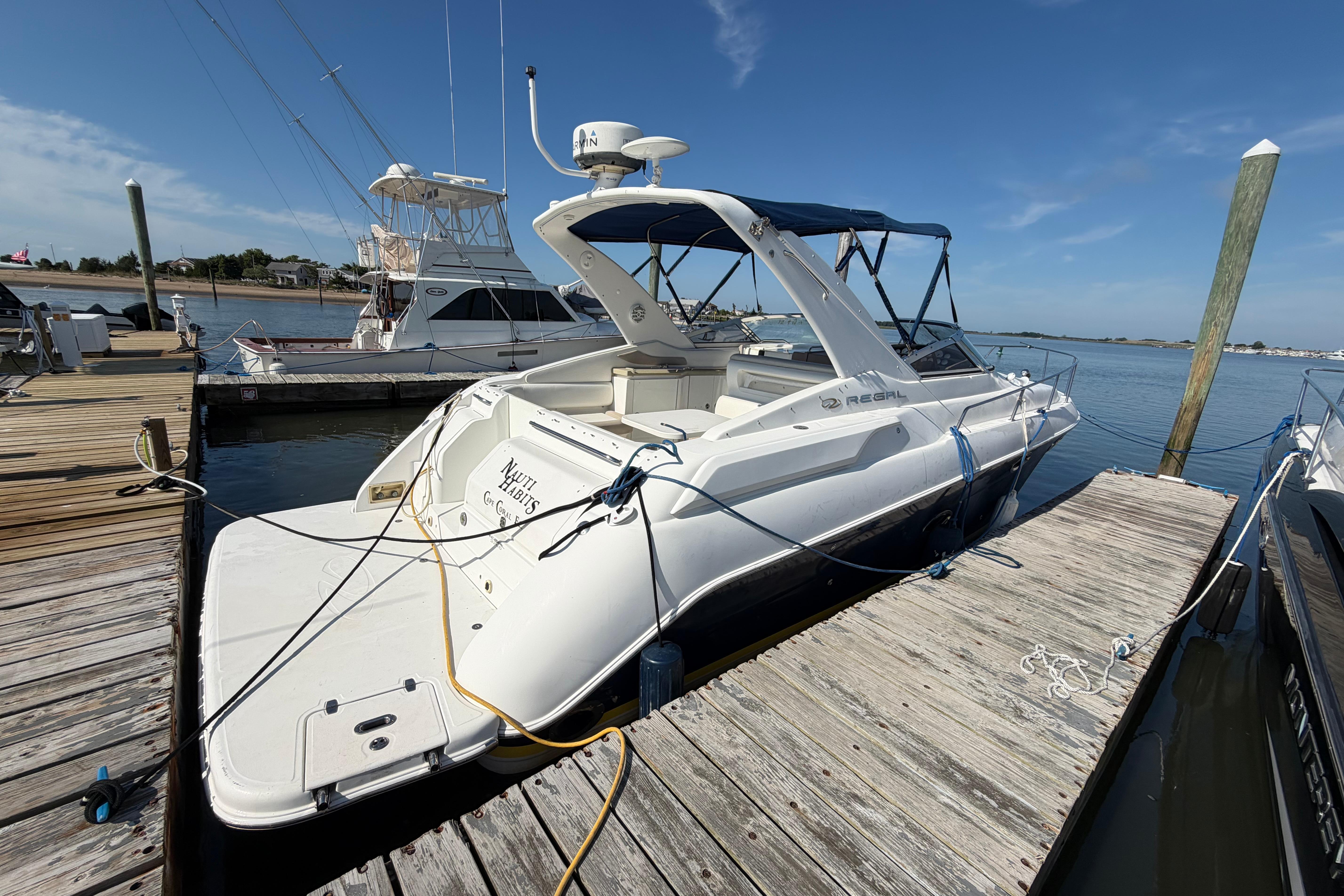 2003 Regal Commodore 3260 yacht docked at marina under clear blue sky.