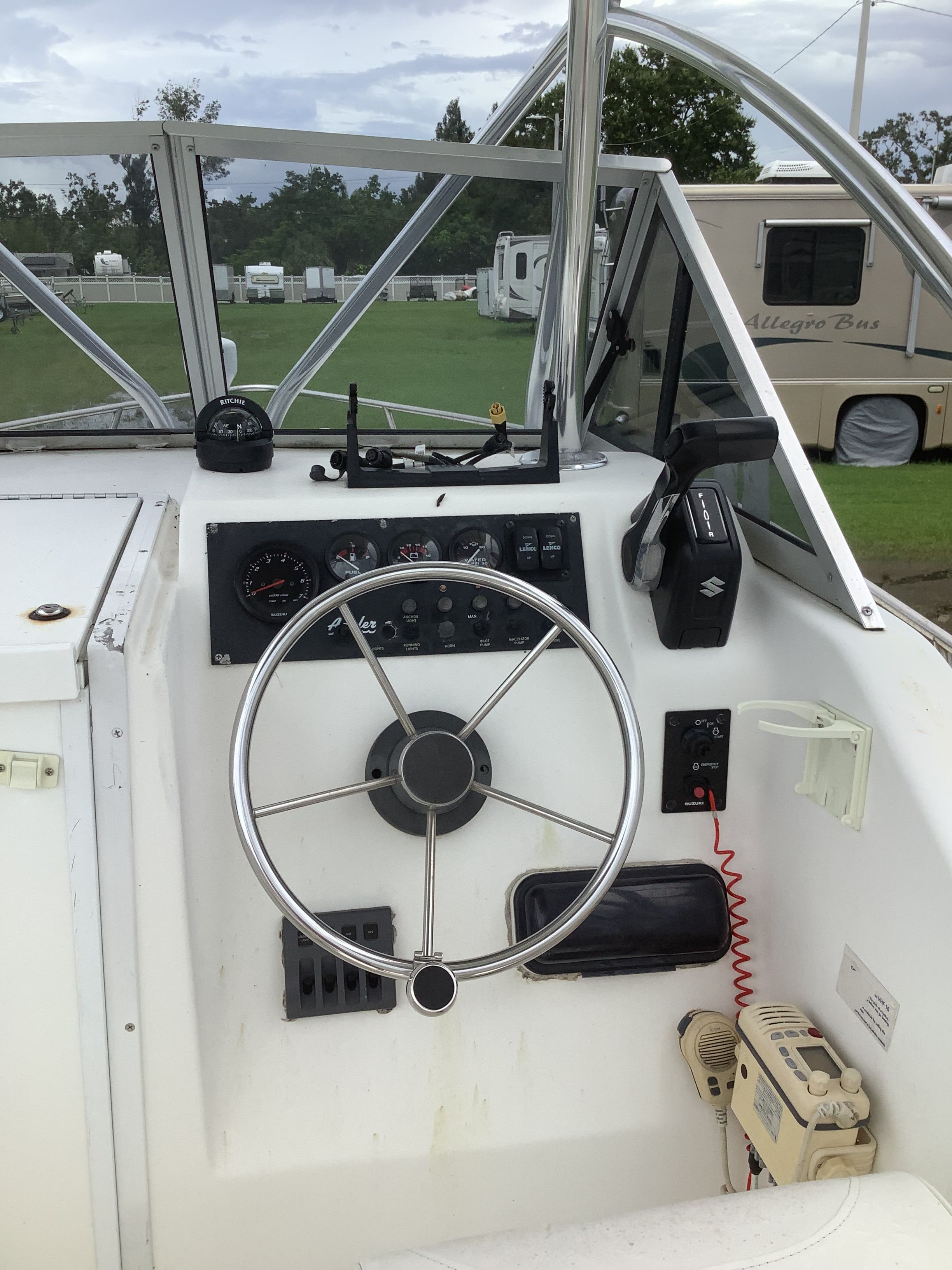 The cockpit of a boat with a steering wheel and dashboard, surrounded by RVs.