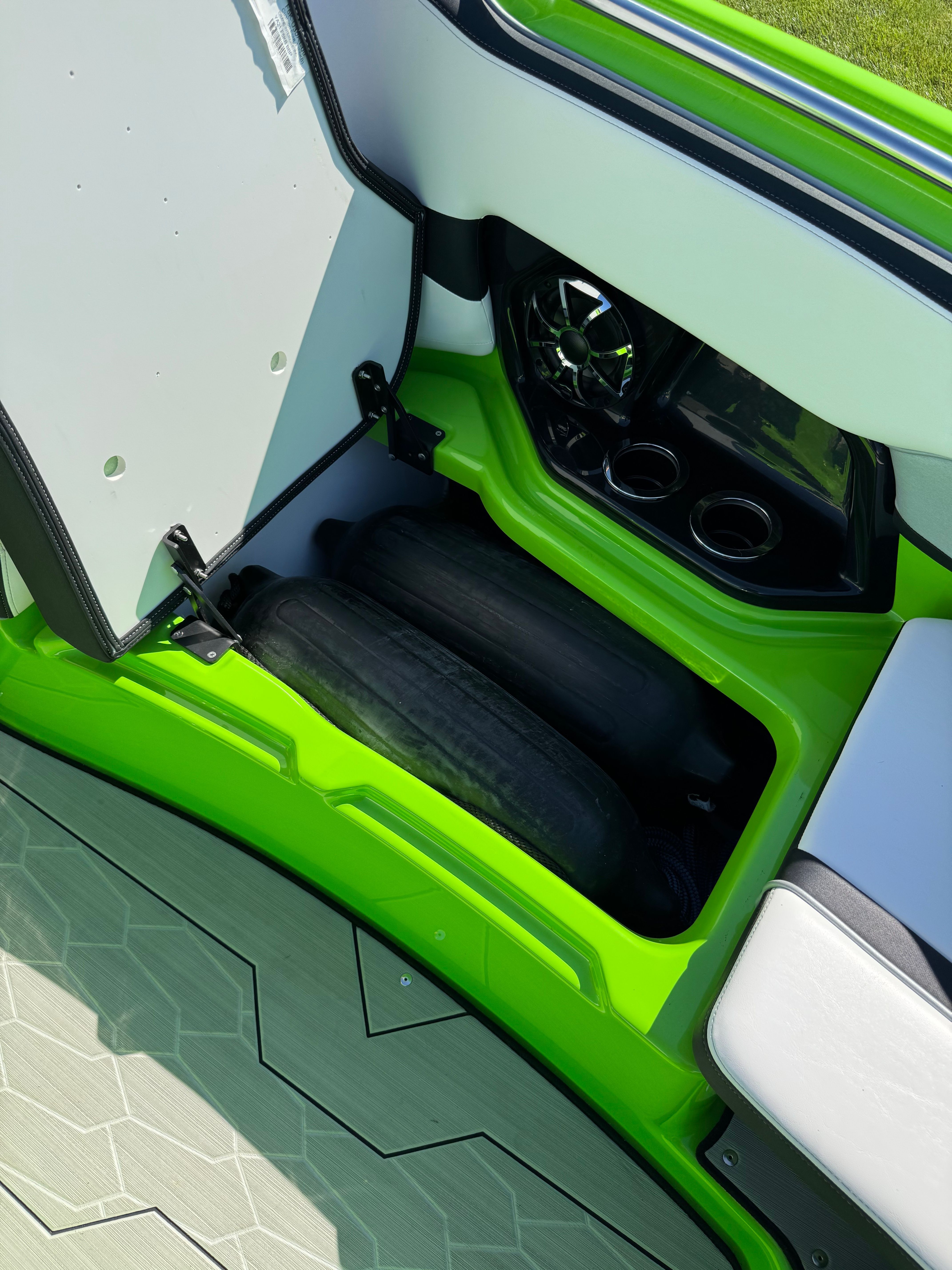 Green storage area in the boat with speaker and cup holders.