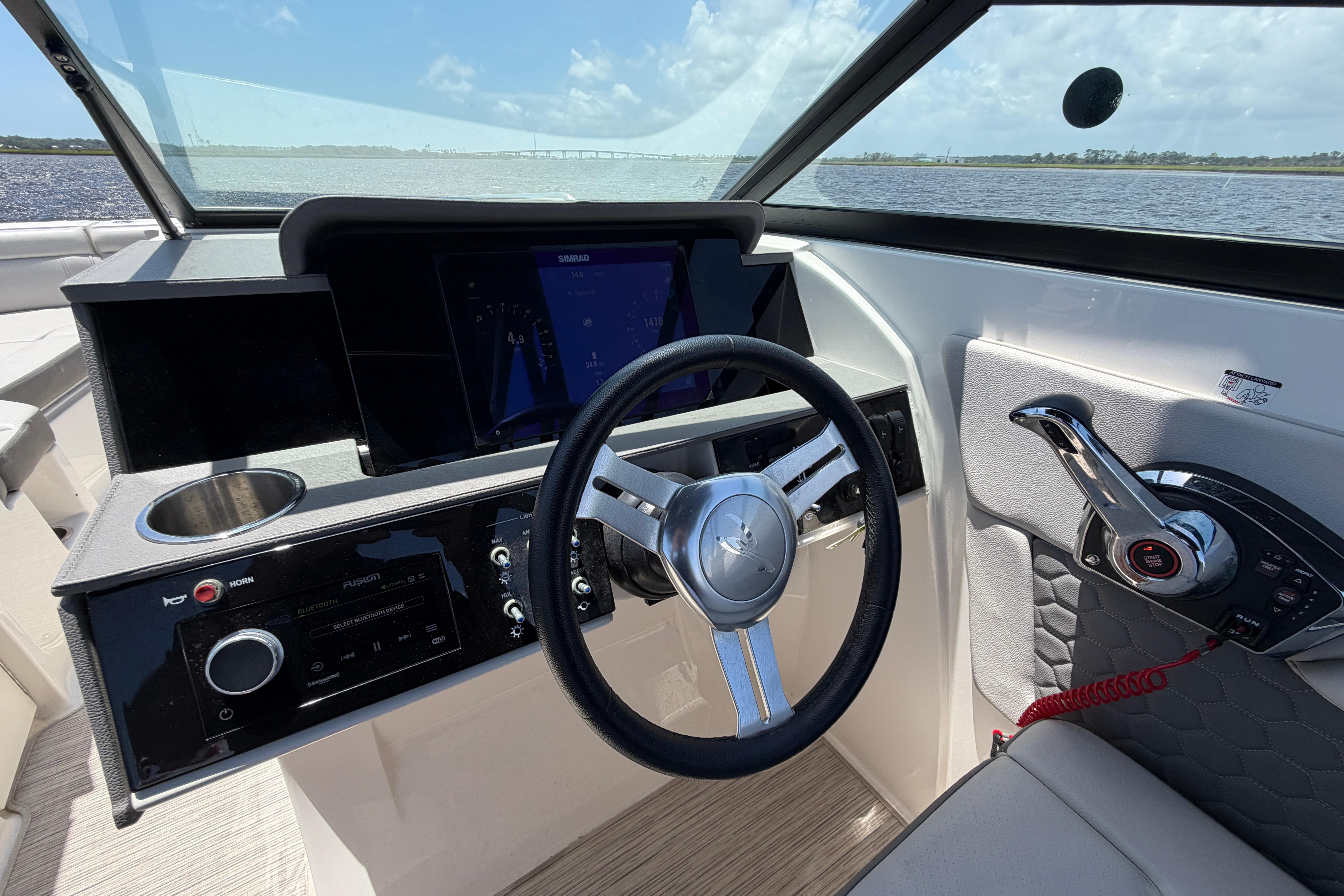 2024 Sea Ray SDX 270 Outboard helm with steering wheel and control panel.