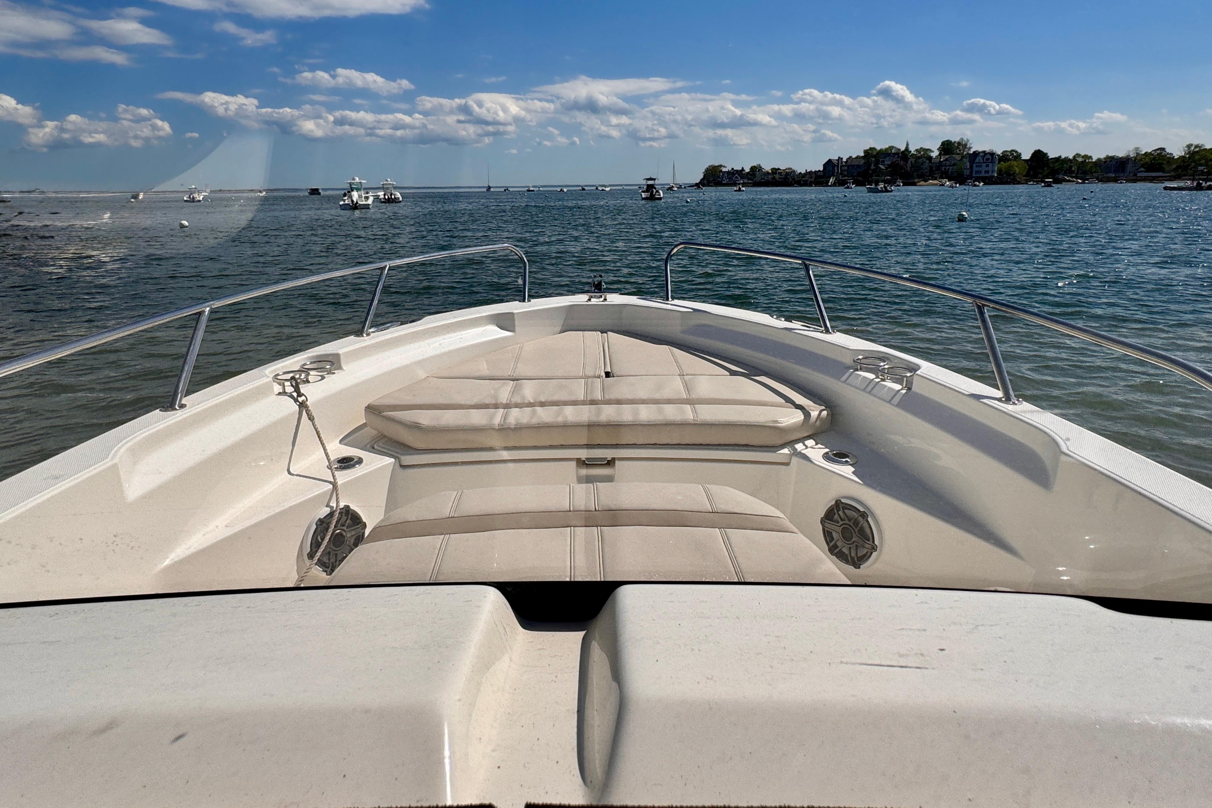 2022 Boston Whaler 220 Dauntless boat on calm water, sunny day, clear sky.