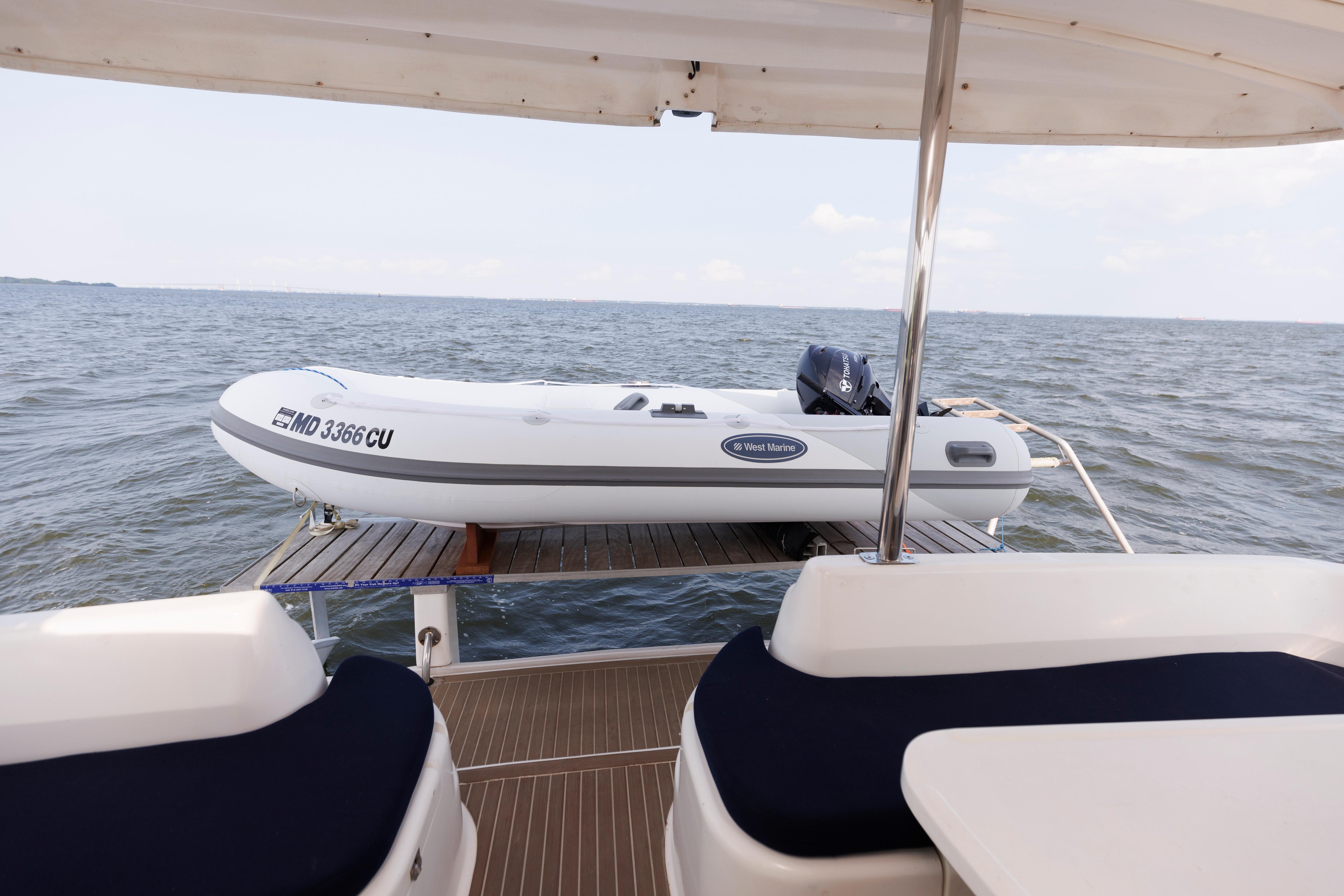 2006 Leopard 43 yacht with dinghy on deck, ocean view in background.