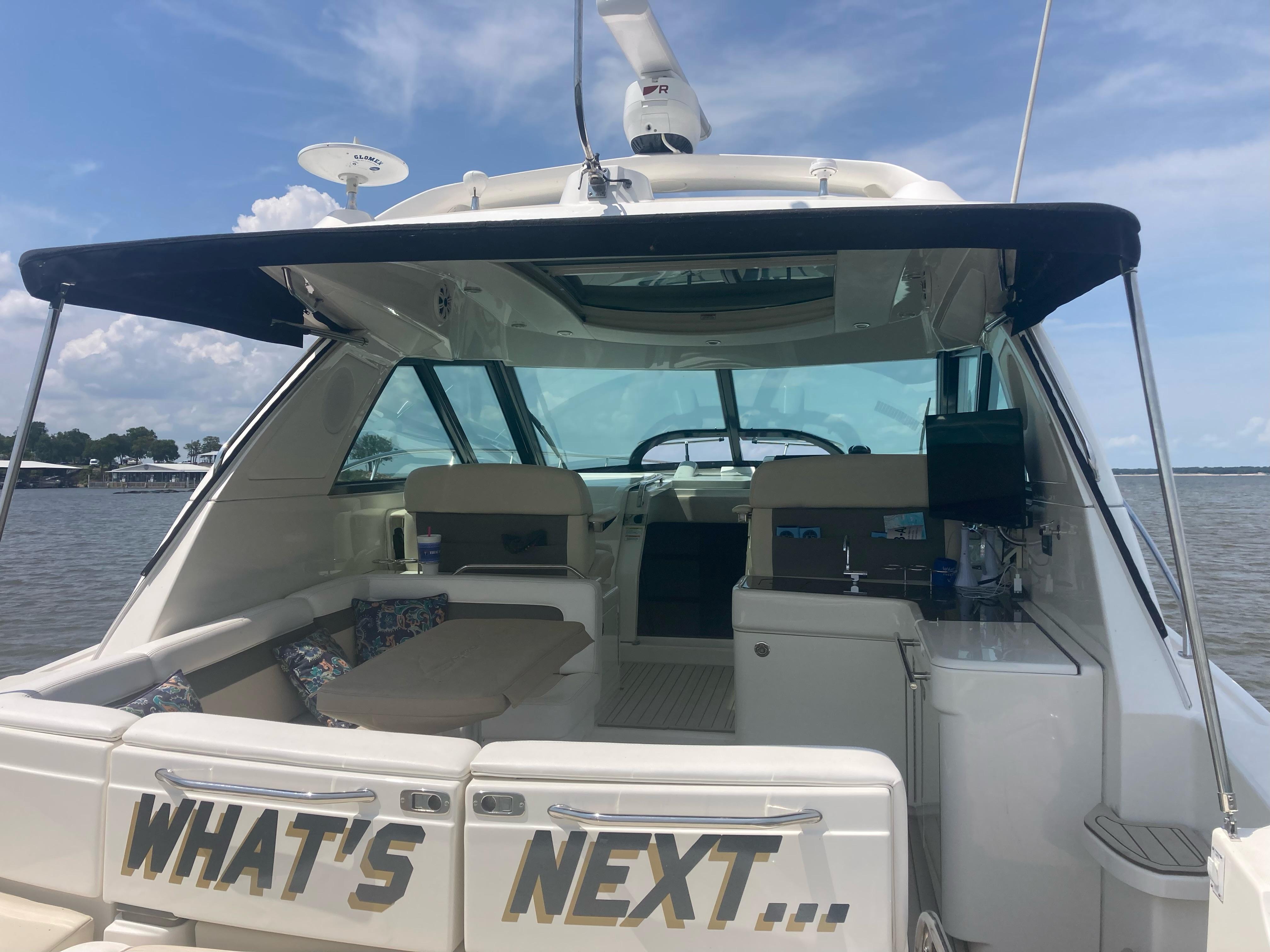 2015 Sea Ray 450 Sundancer yacht with open deck, lake view, and "What's Next" text.