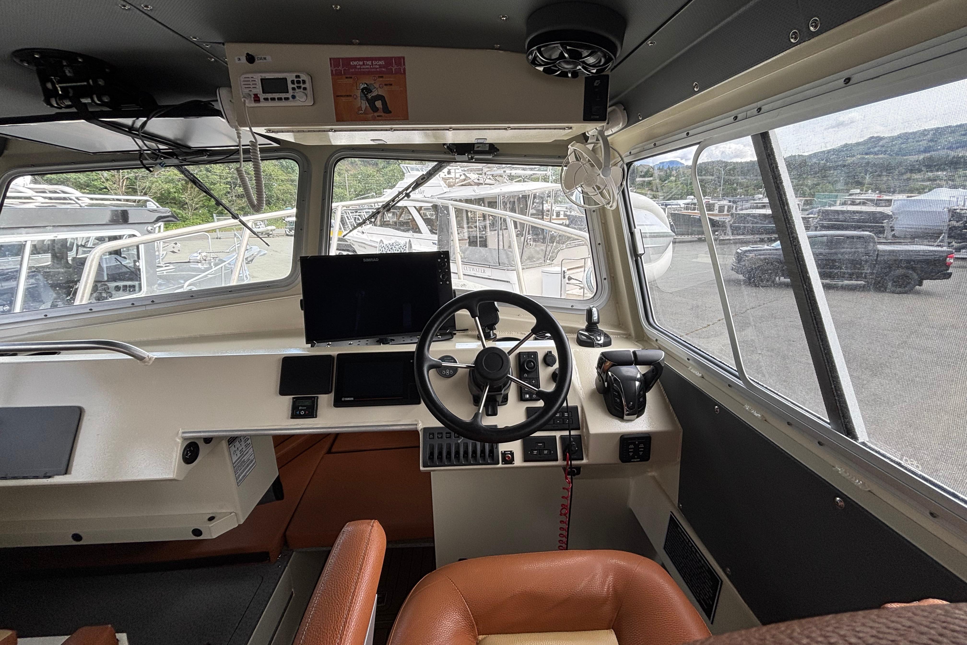 Interior cockpit of 2022 North River Seahawk Offshore 2900SXL boat, featuring steering wheel and controls.