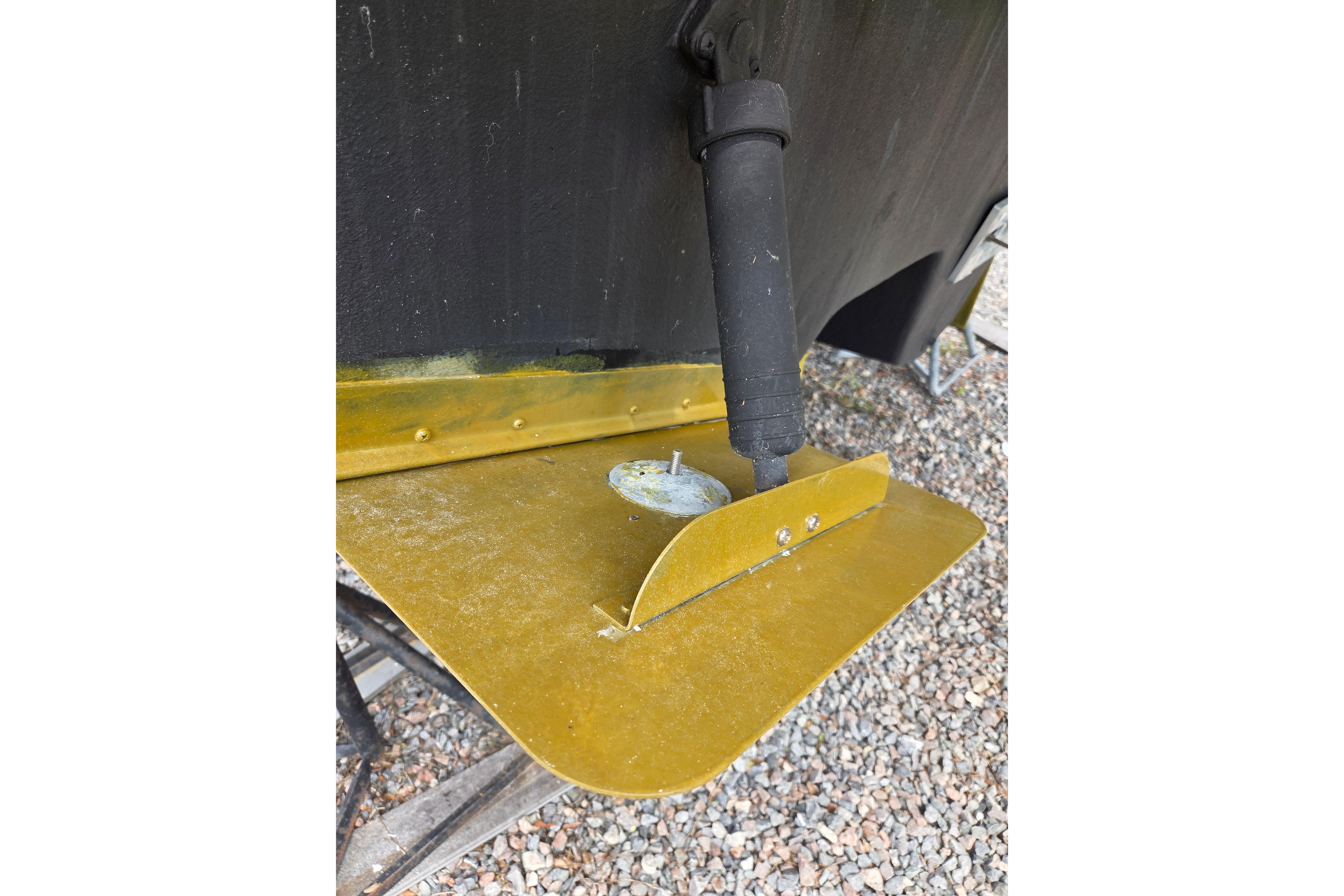 Trim tab of a 2000 Sea Ray 340 Sundancer boat on gravel surface.