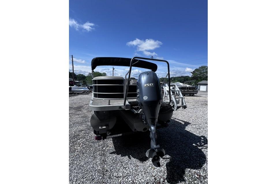 2021 Bennington 23 SSRX pontoon boat with 150 HP engine, parked on gravel lot.