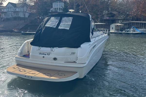 2004 Sea Ray 380 Sundancer yacht on a calm lake near waterfront homes.