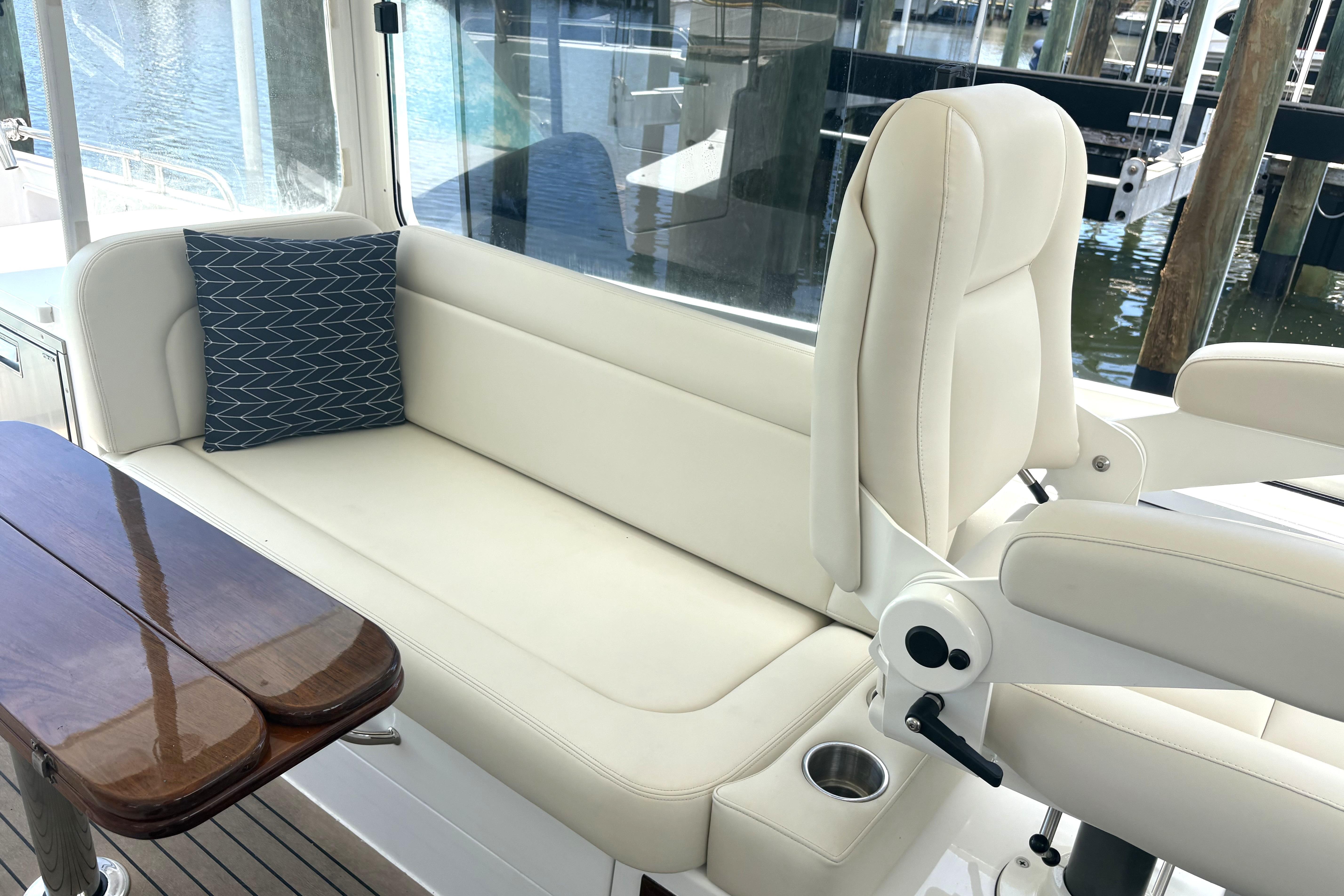 Luxurious seating area on 2024 MJM 35z yacht with elegant white upholstery and wooden table.