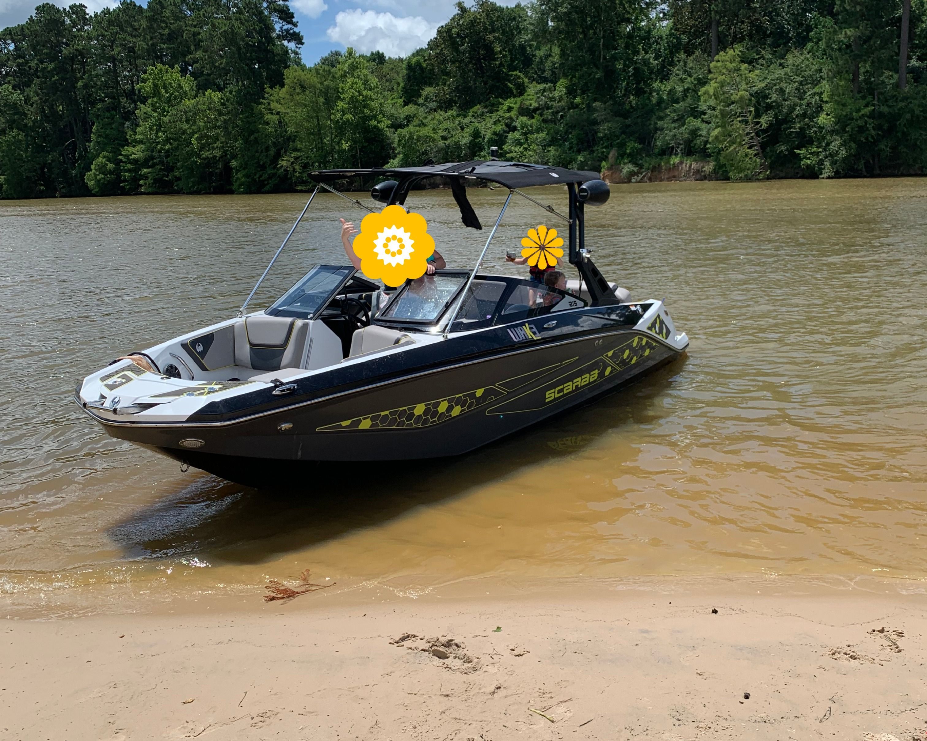 2020 Scarab Wake 215 boat at sandy riverbank.