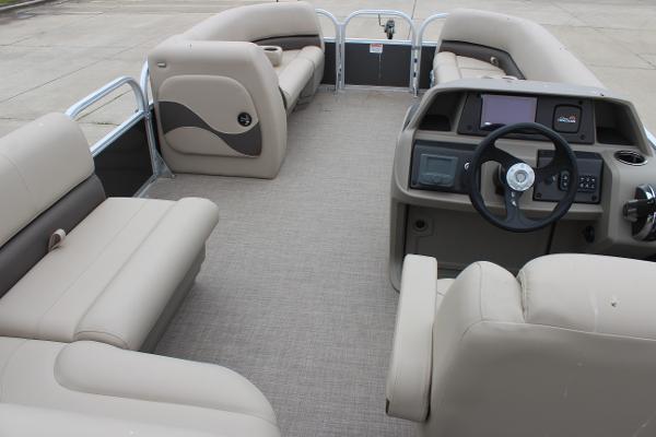 2025 Sun Tracker Party Barge 18 DLX interior with beige seating and steering console.