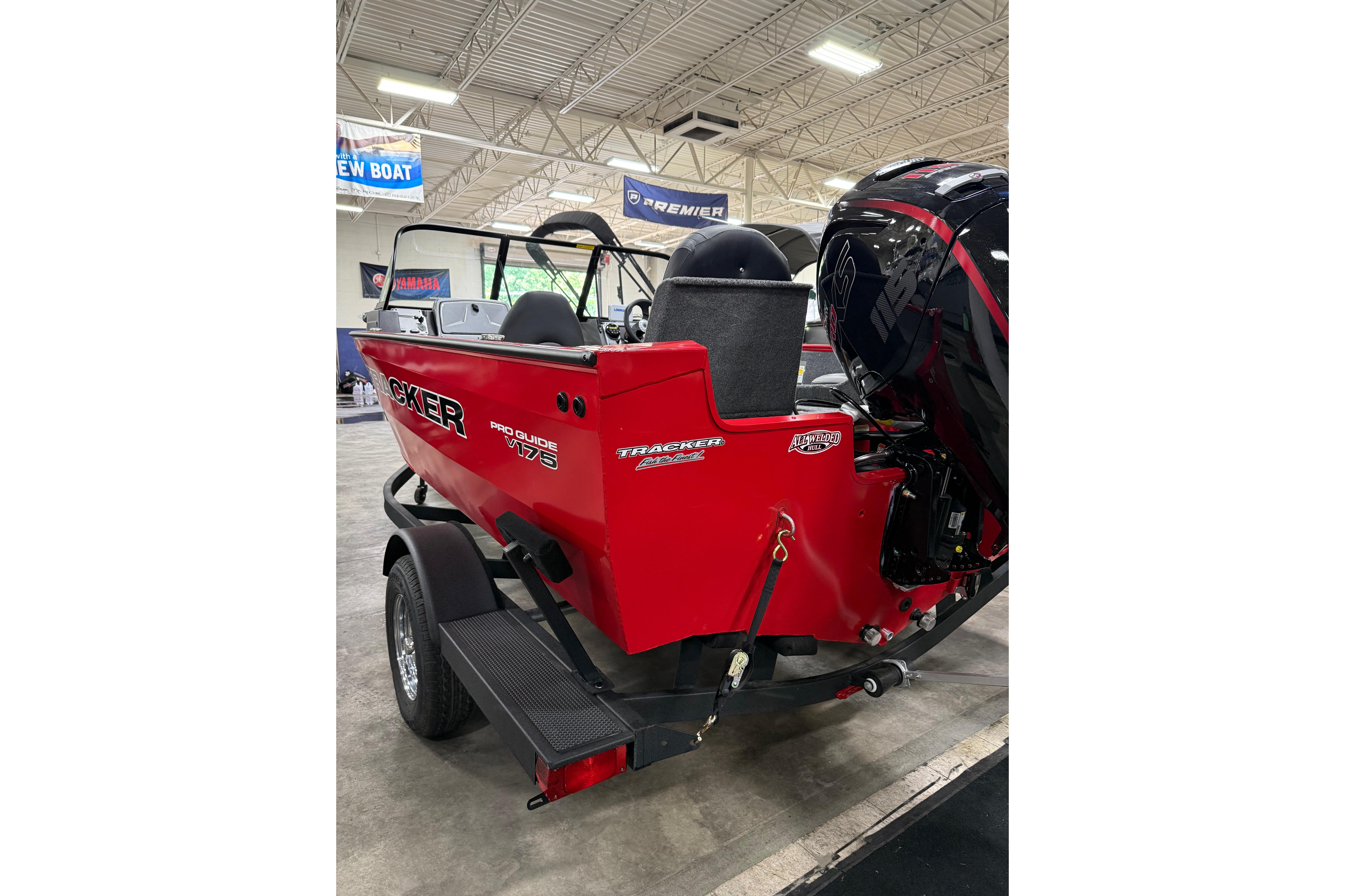 2026 Tracker Pro Guide V-175 Combo boat in showroom, red exterior, on trailer.