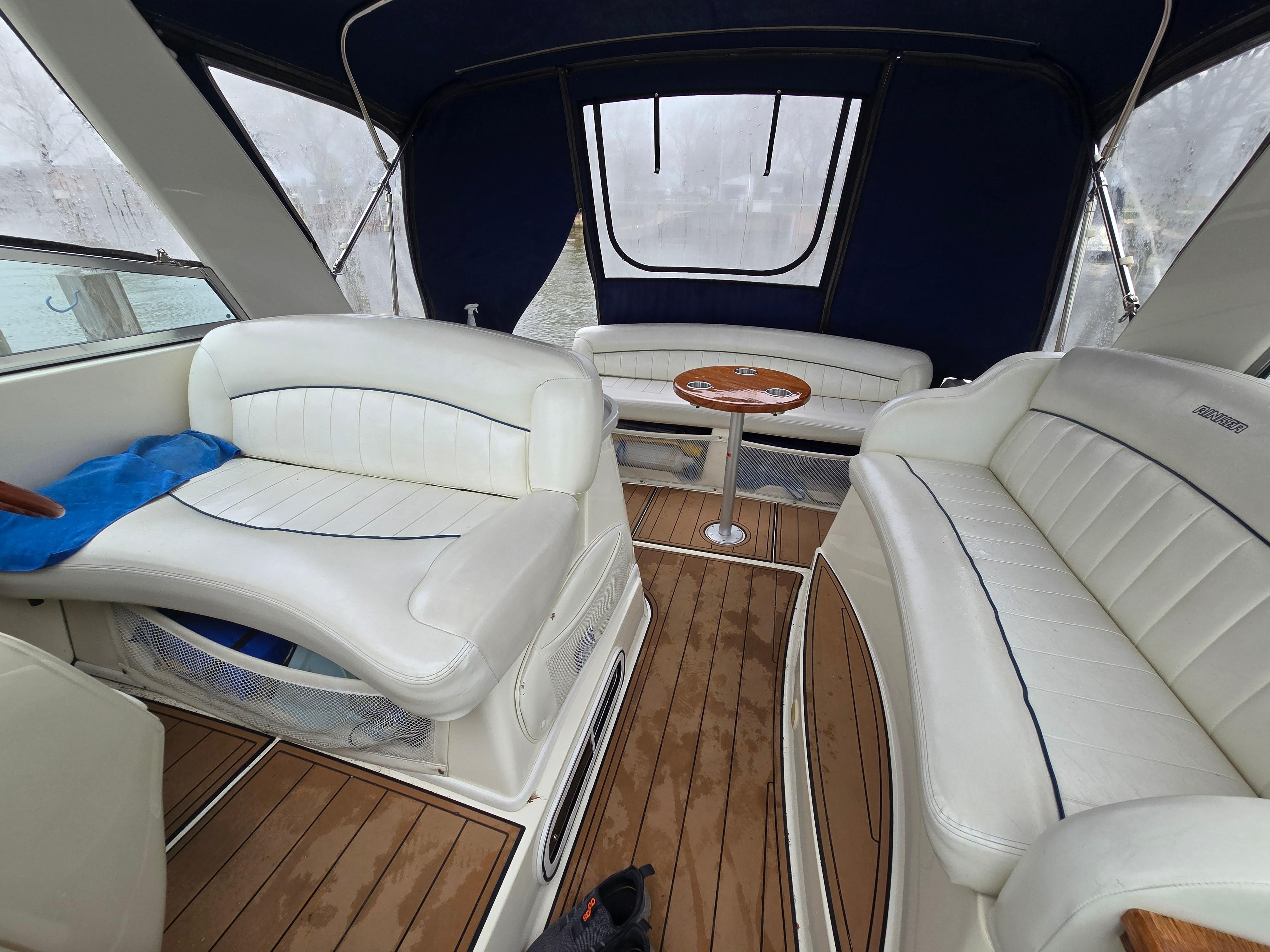 1998 Rinker 330 Fiesta Vee boat interior with white seating and wooden flooring.